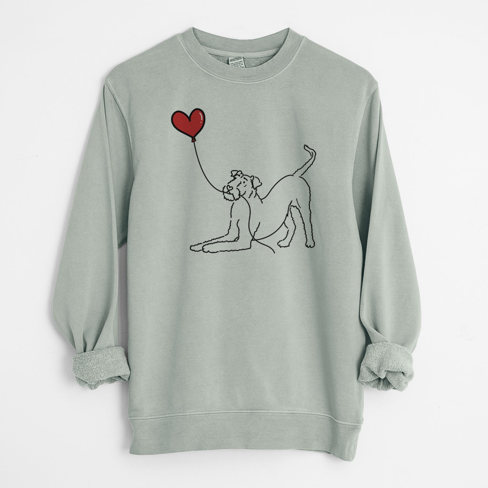 Minimalist line drawing of an Airedale Terrier Heart String holding a heart balloon on a Sage Unisex pigment dyed crew sweatshirt