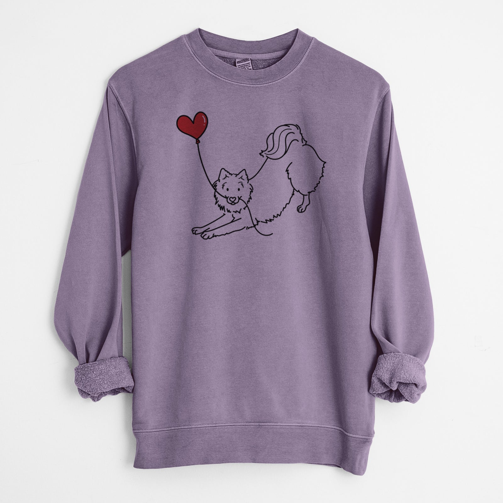 Minimalist line drawing of an American Eskimo Heart String holding a heart balloon on a Plum Unisex pigment dyed crew sweatshirt