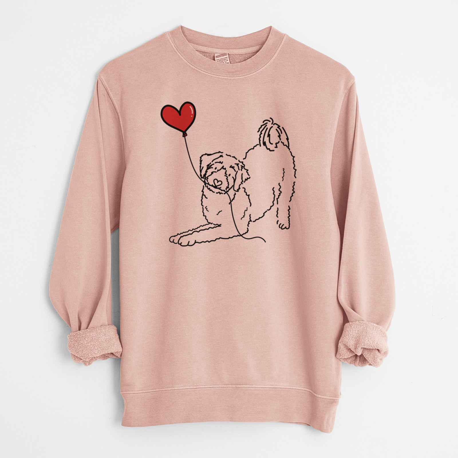 Minimalist line drawing of an Aussiedoodle Heart String holding a heart balloon on a Dusty Pink Unisex pigment dyed crew sweatshirt