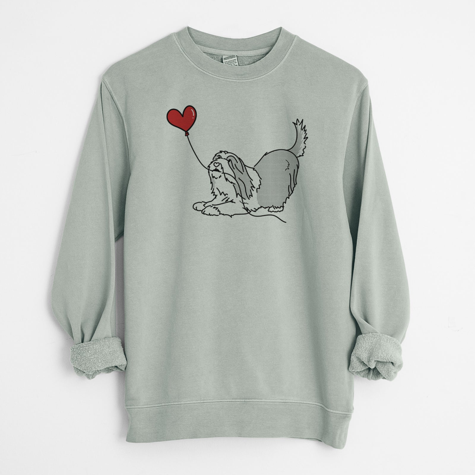 Minimalist line drawing of a Bearded Collie Heart String holding a heart balloon on a Sage Unisex pigment dyed crew sweatshirt