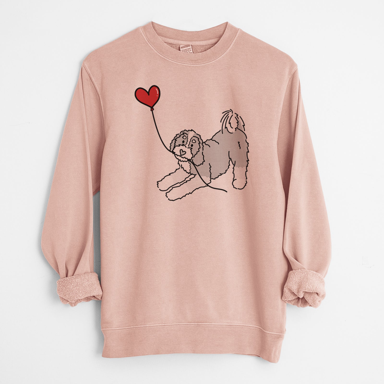 Minimalist line drawing of a Bernedoodle Heart String holding a heart balloon on a Dusty Pink Unisex pigment dyed crew sweatshirt