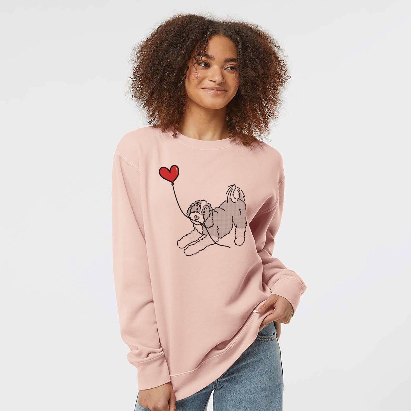 Minimalist line drawing of a Bernedoodle Heart String holding a heart balloon on a Dusty Pink Unisex pigment dyed crew sweatshirt