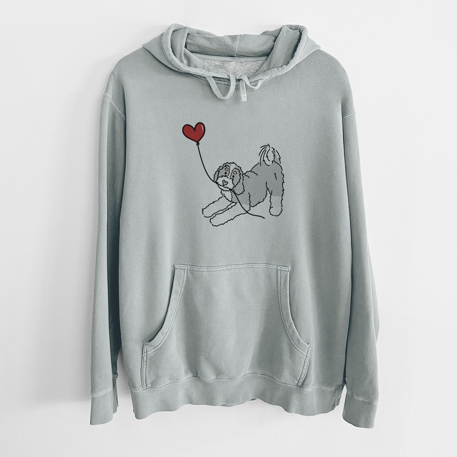 Minimalist line drawing of a Bernedoodle Heart String holding a heart balloon on a Sage Unisex pigment dyed hoodie