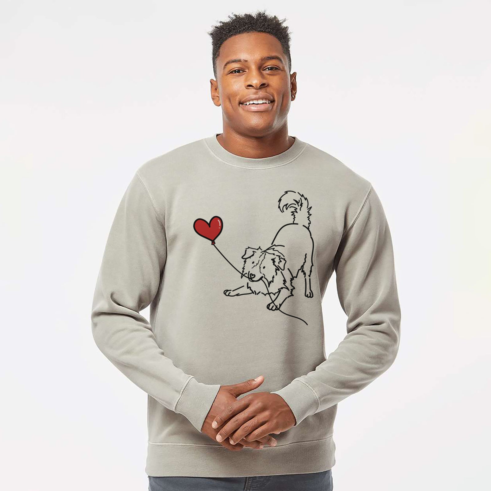 Minimalist line drawing of a Border Collie Heart String holding a heart balloon on a Cement Unisex pigment dyed crew sweatshirt