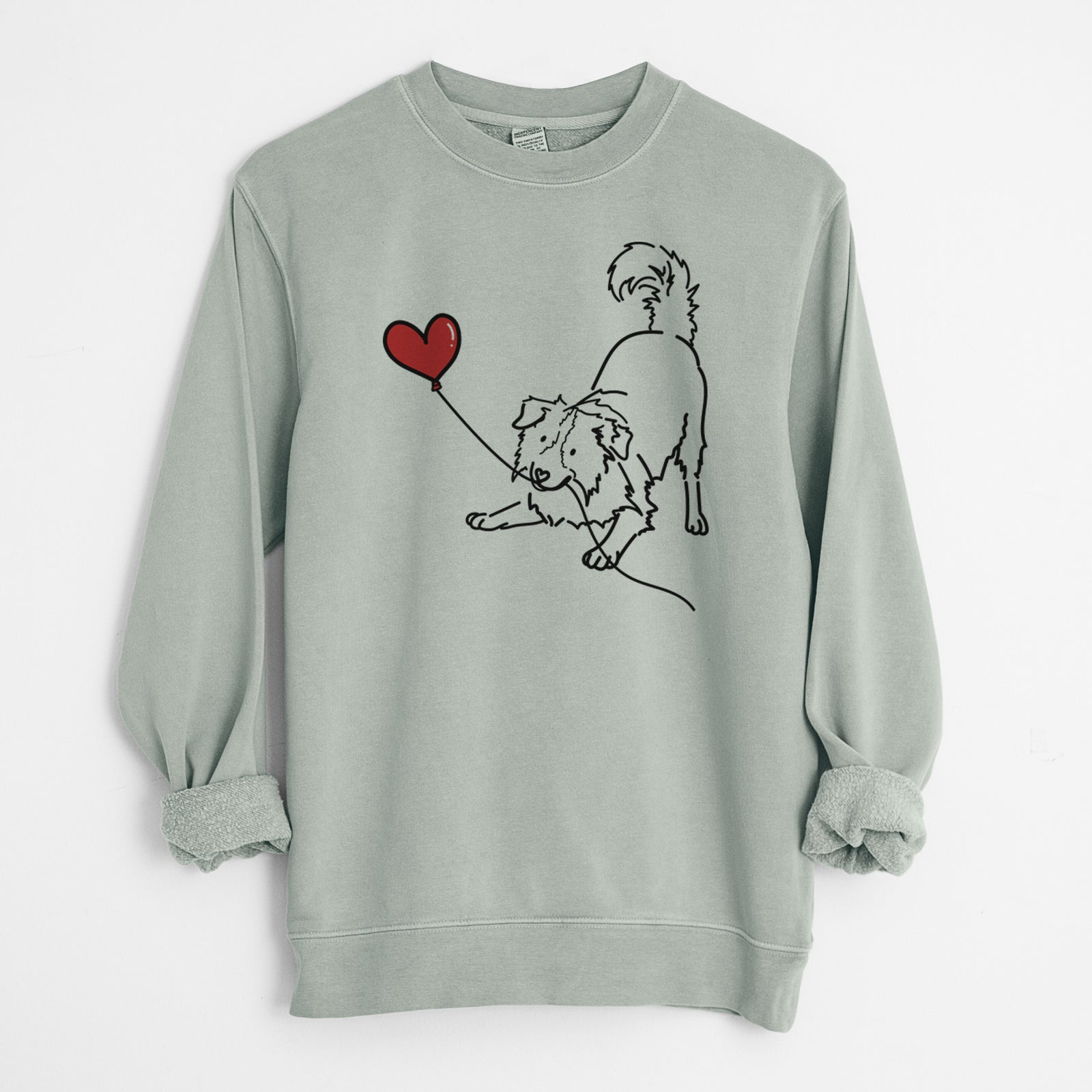 Minimalist line drawing of a Border Collie Heart String holding a heart balloon on a Sage Unisex pigment dyed crew sweatshirt