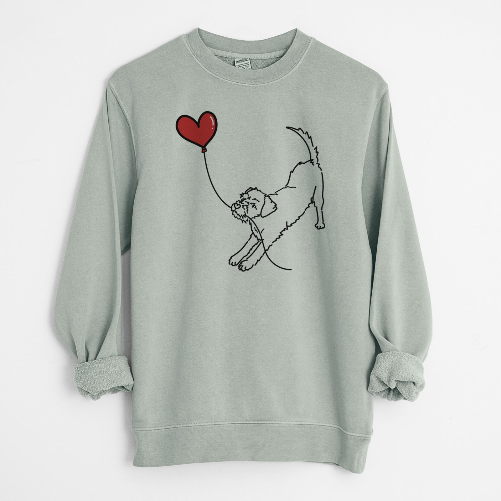 Minimalist line drawing of a Border Terrier Heart String holding a heart balloon on a Sage Unisex pigment dyed crew sweatshirt