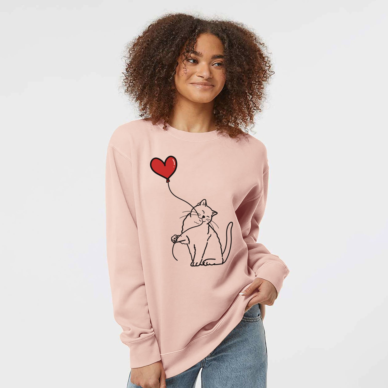 Minimalist line drawing of a British Shorthair Cat Heart String holding a heart balloon on a Dusty Pink Unisex pigment dyed crew sweatshirt
