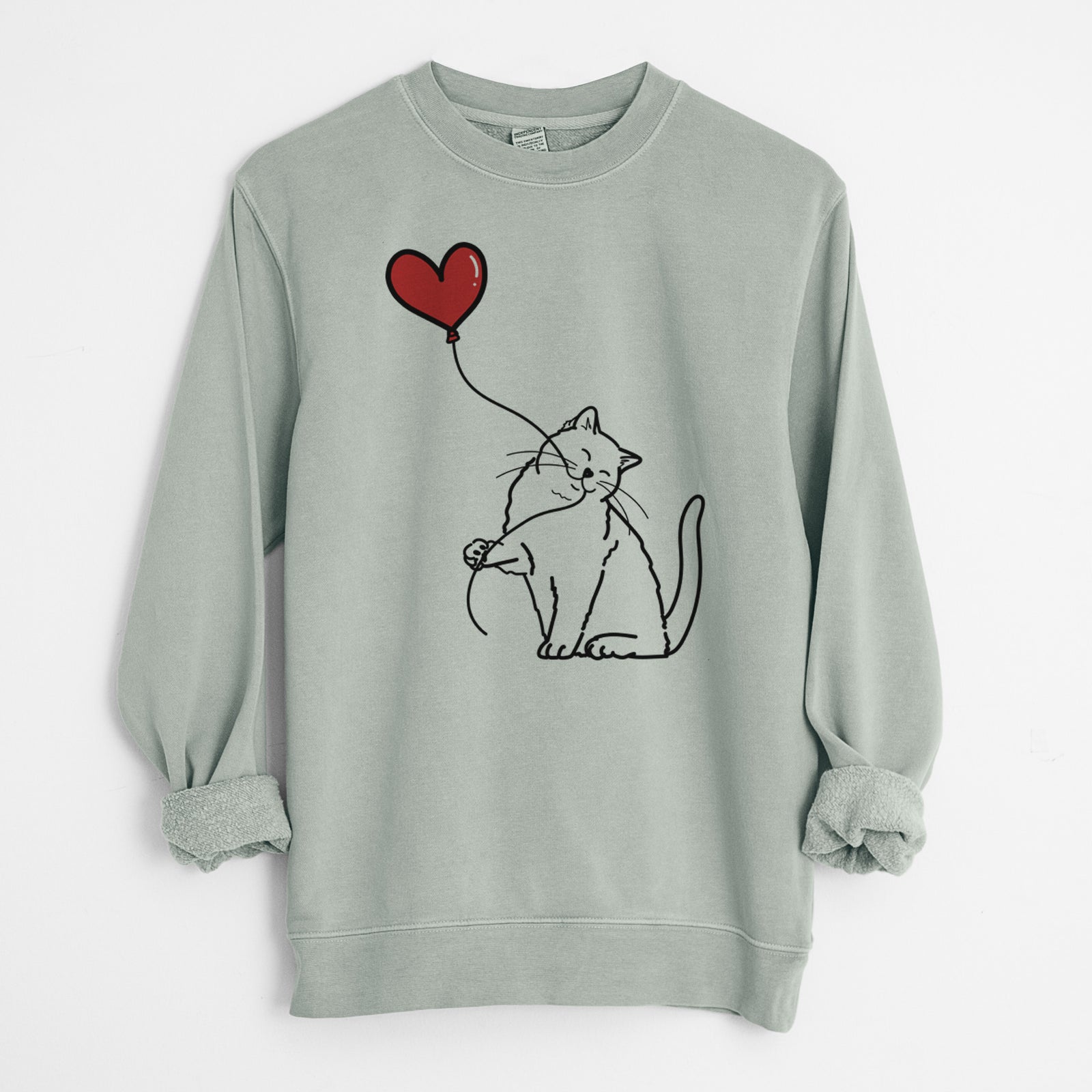 Minimalist line drawing of a British Shorthair Cat Heart String holding a heart balloon on a Sage Unisex pigment dyed crew sweatshirt