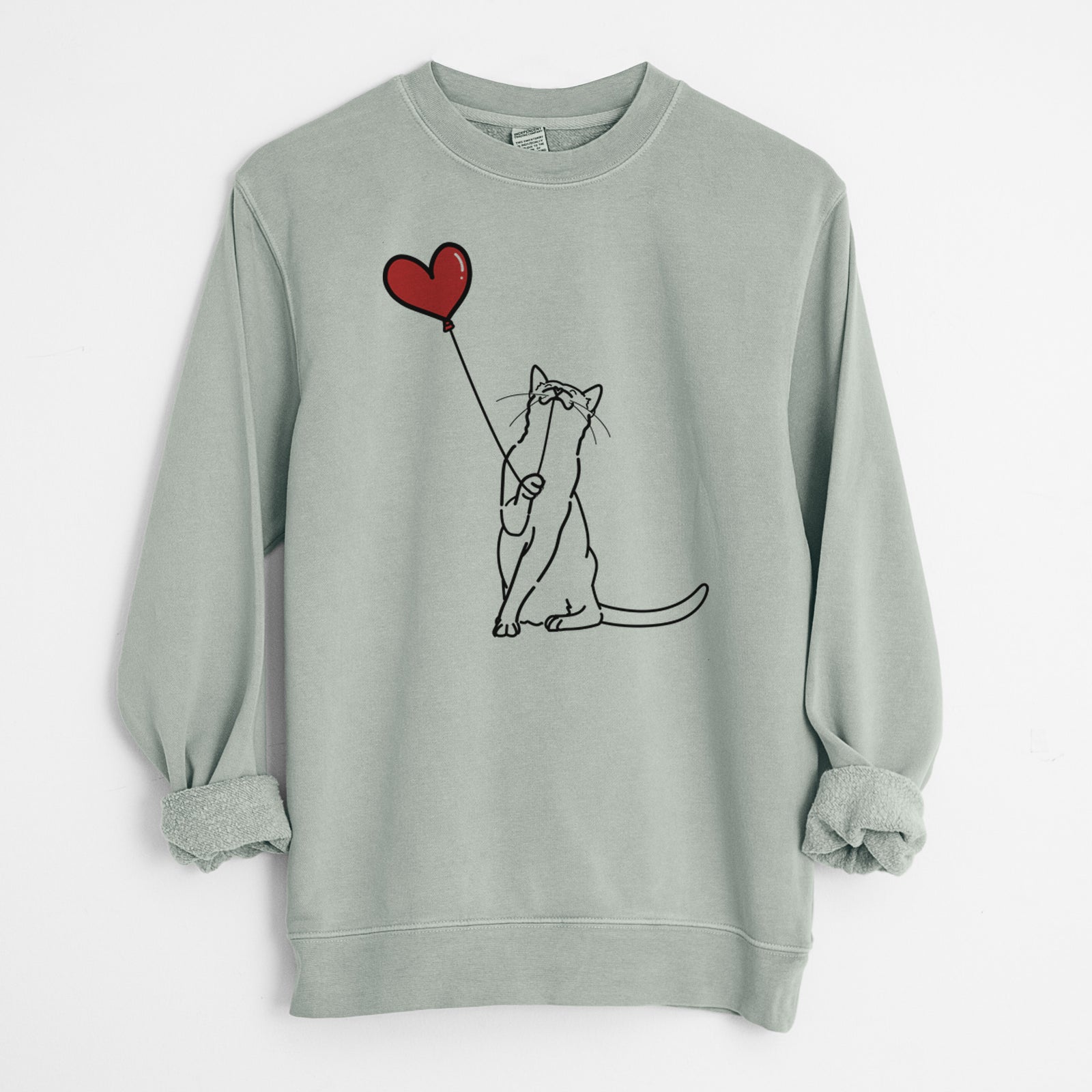 Minimalist line drawing of a Cat Heart String holding a heart balloon on a Sage Unisex pigment dyed crew sweatshirt