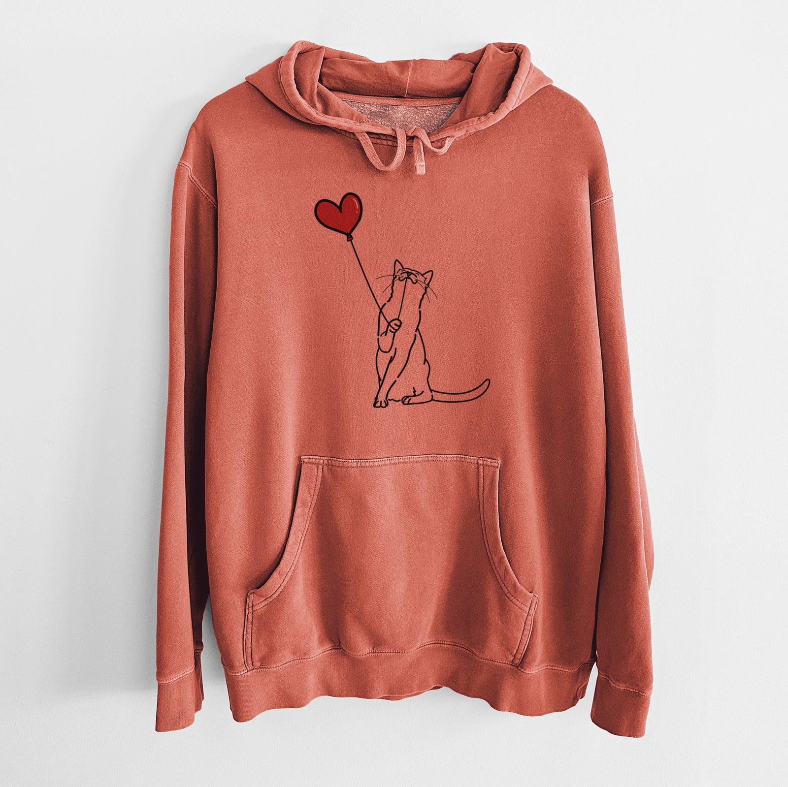 Minimalist line drawing of a Cat Heart String holding a heart balloon on an Amber Unisex pigment dyed hoodie