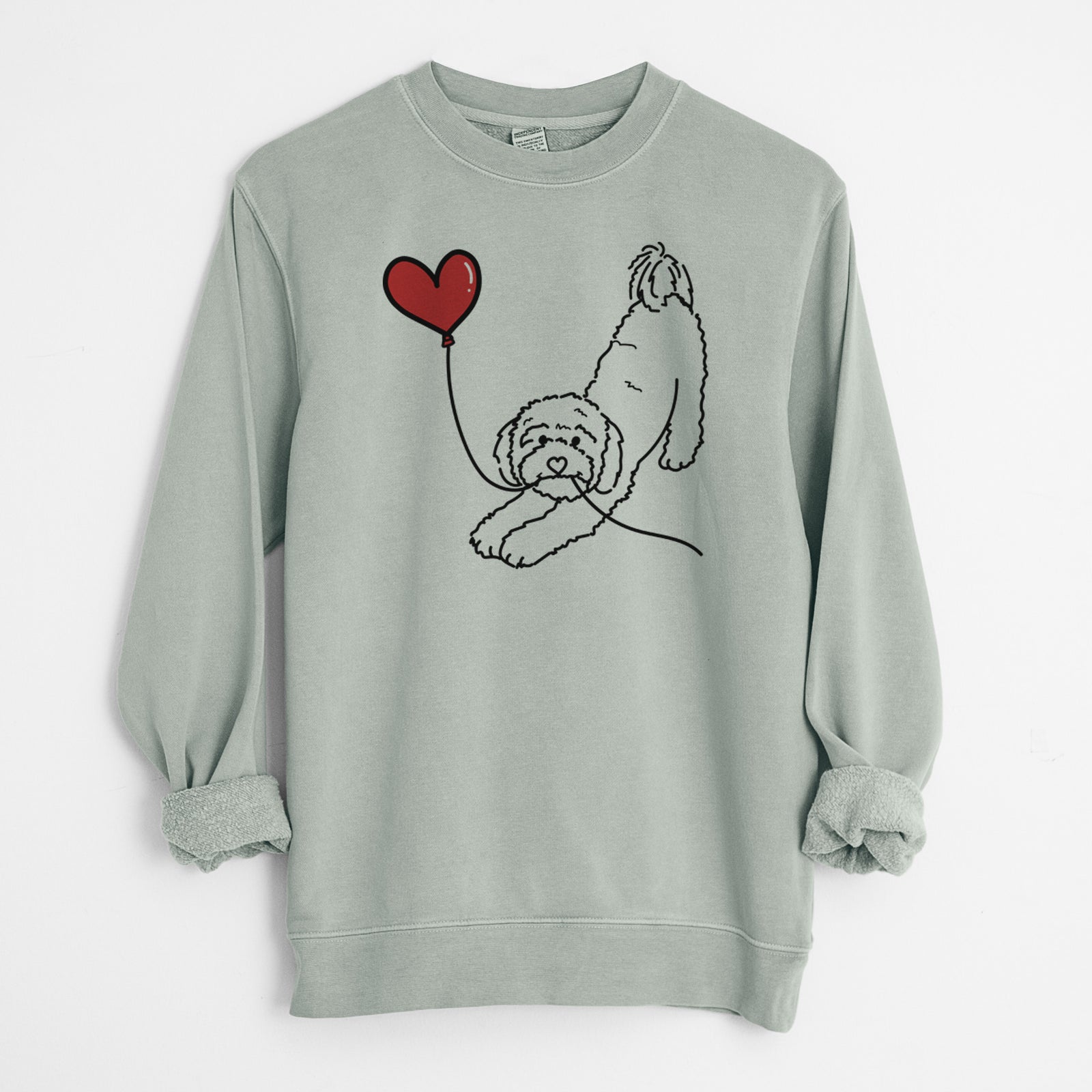 Minimalist line drawing of a Cavapoo Heart String holding a heart balloon on a Sage Unisex pigment dyed crew sweatshirt