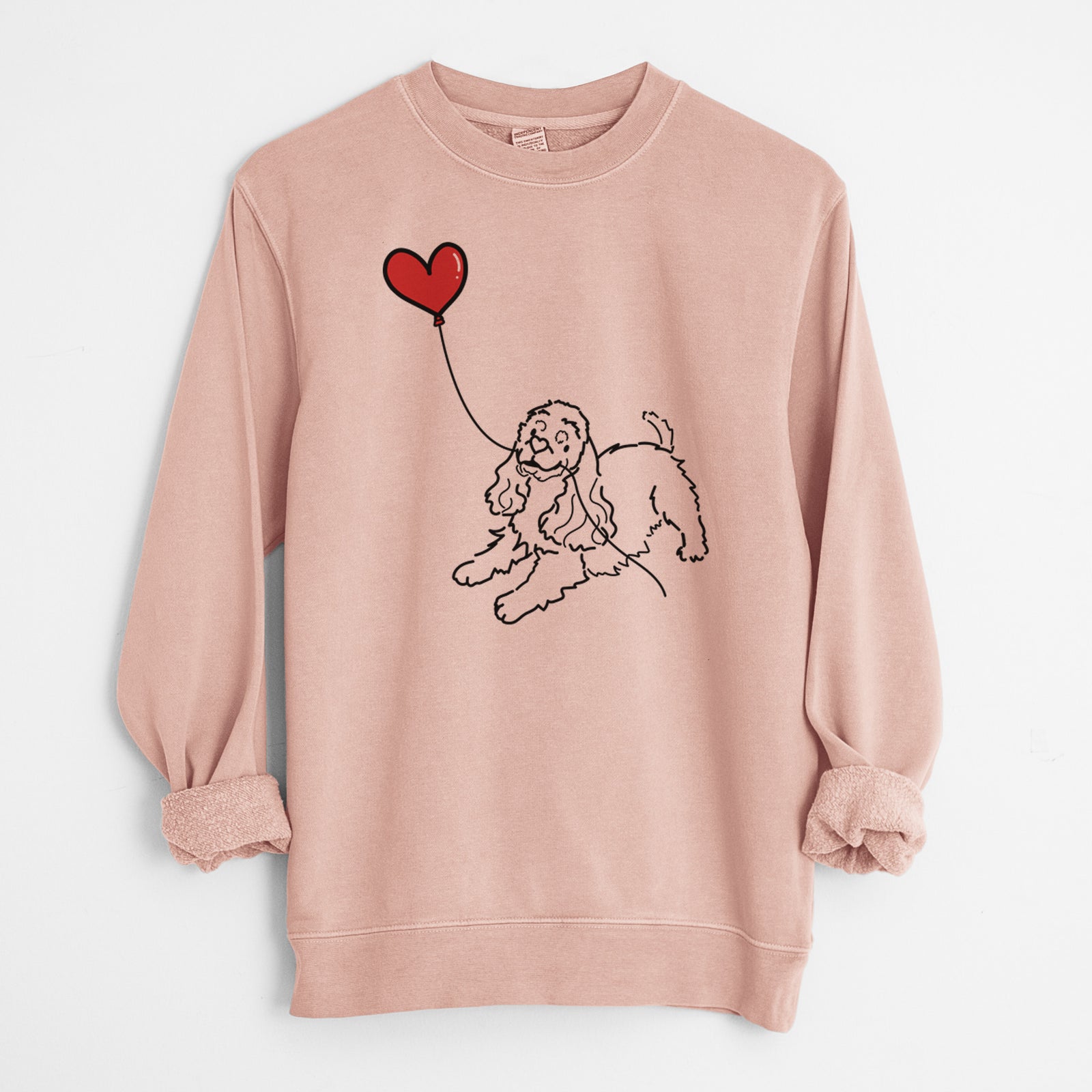 Minimalist line drawing of a Cocker Spaniel Heart String holding a heart balloon on a Dusty Pink Unisex pigment dyed crew sweatshirt