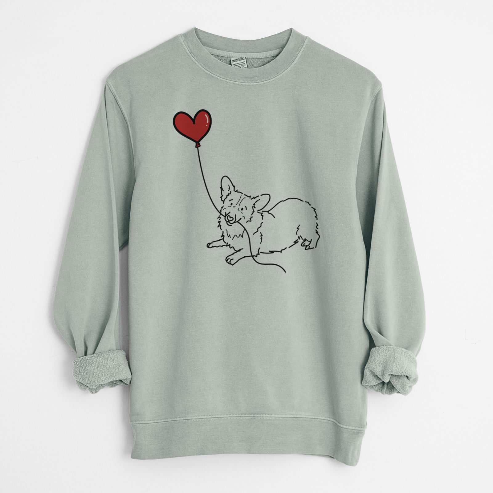Minimalist line drawing of a Corgi Heart String holding a heart balloon on a Sage Unisex pigment dyed crew sweatshirt