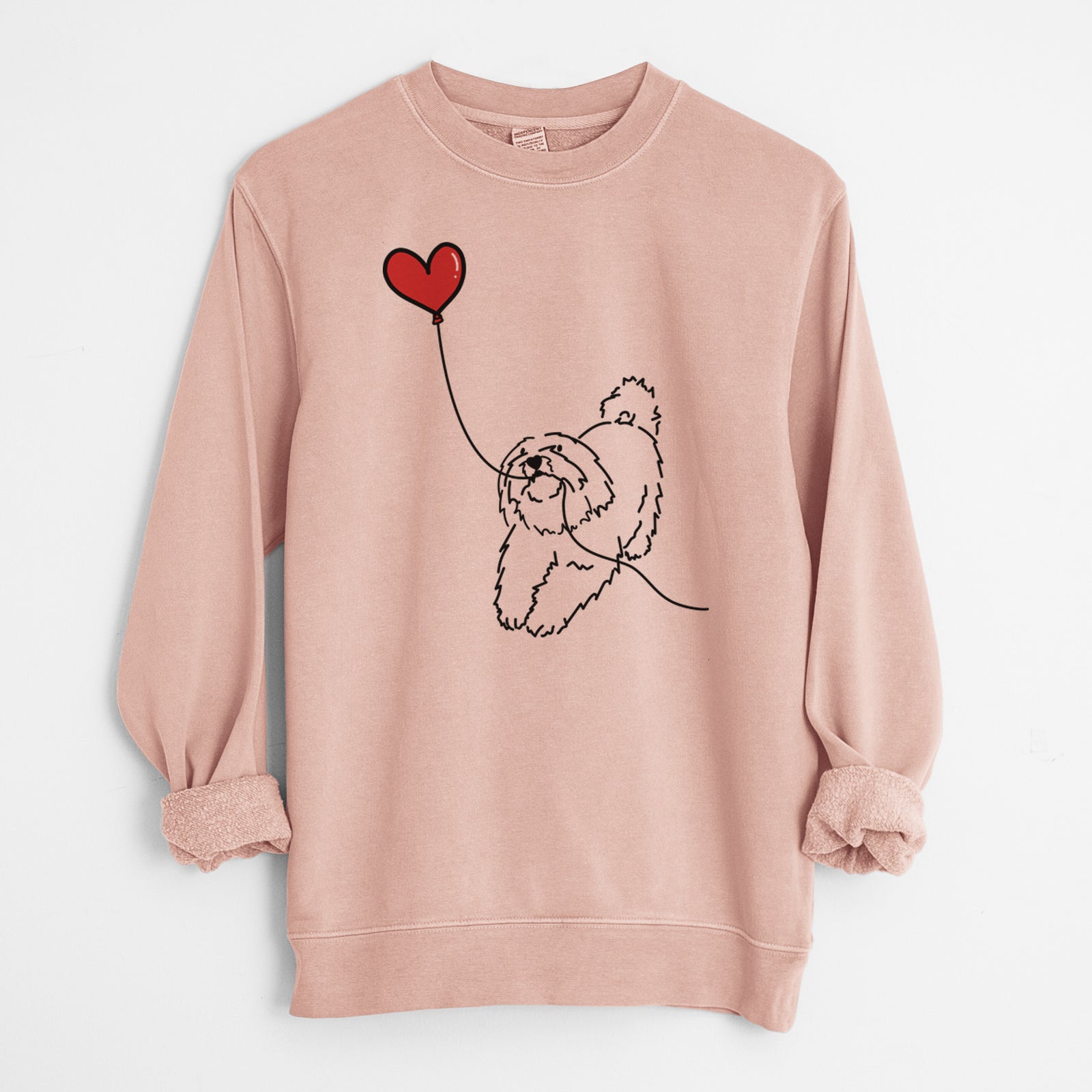 Minimalist line drawing of a Coton de Tulear Heart String holding a heart balloon on a Dusty Pink Unisex pigment dyed crew sweatshirt