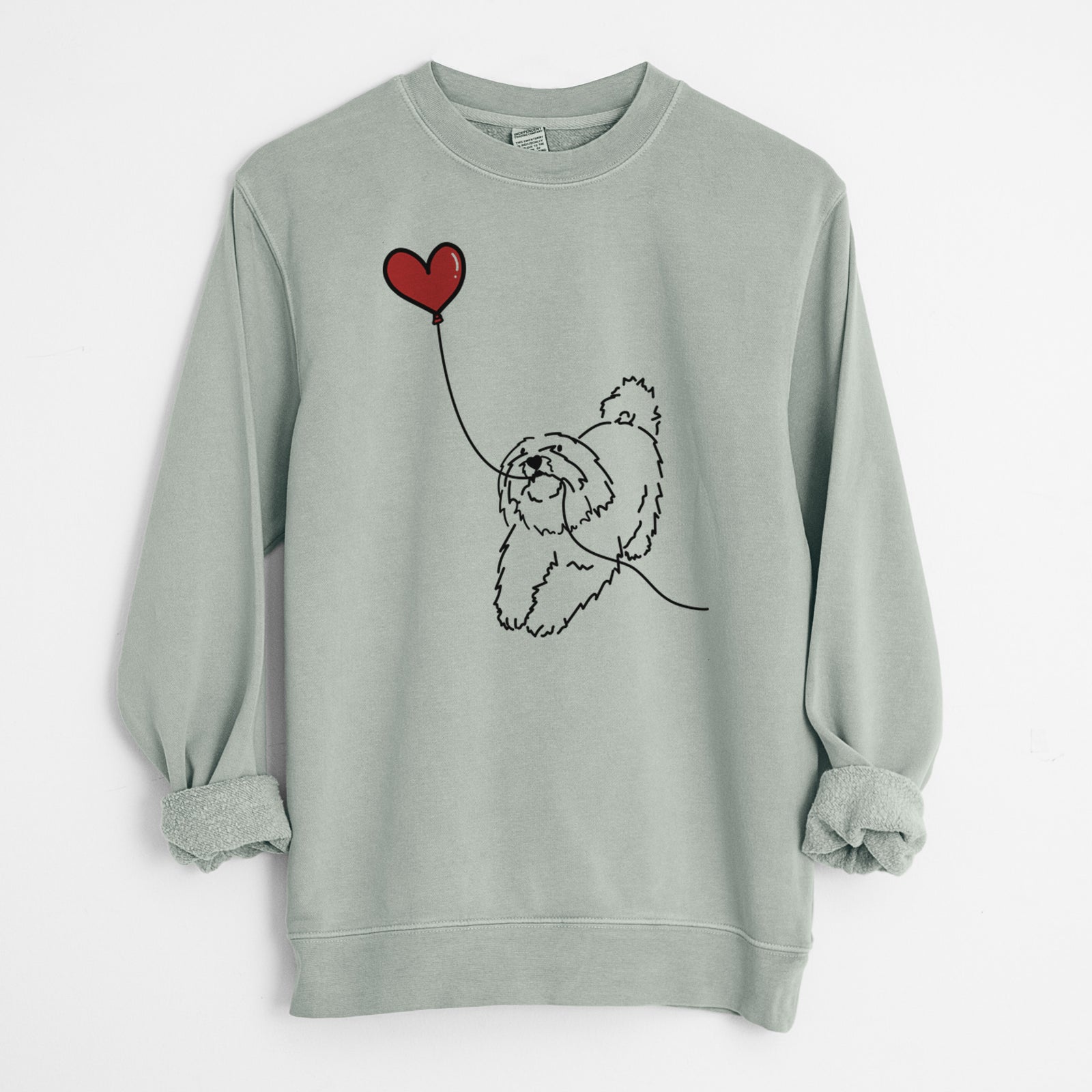 Minimalist line drawing of a Coton de Tulear Heart String holding a heart balloon on a Sage Unisex pigment dyed crew sweatshirt