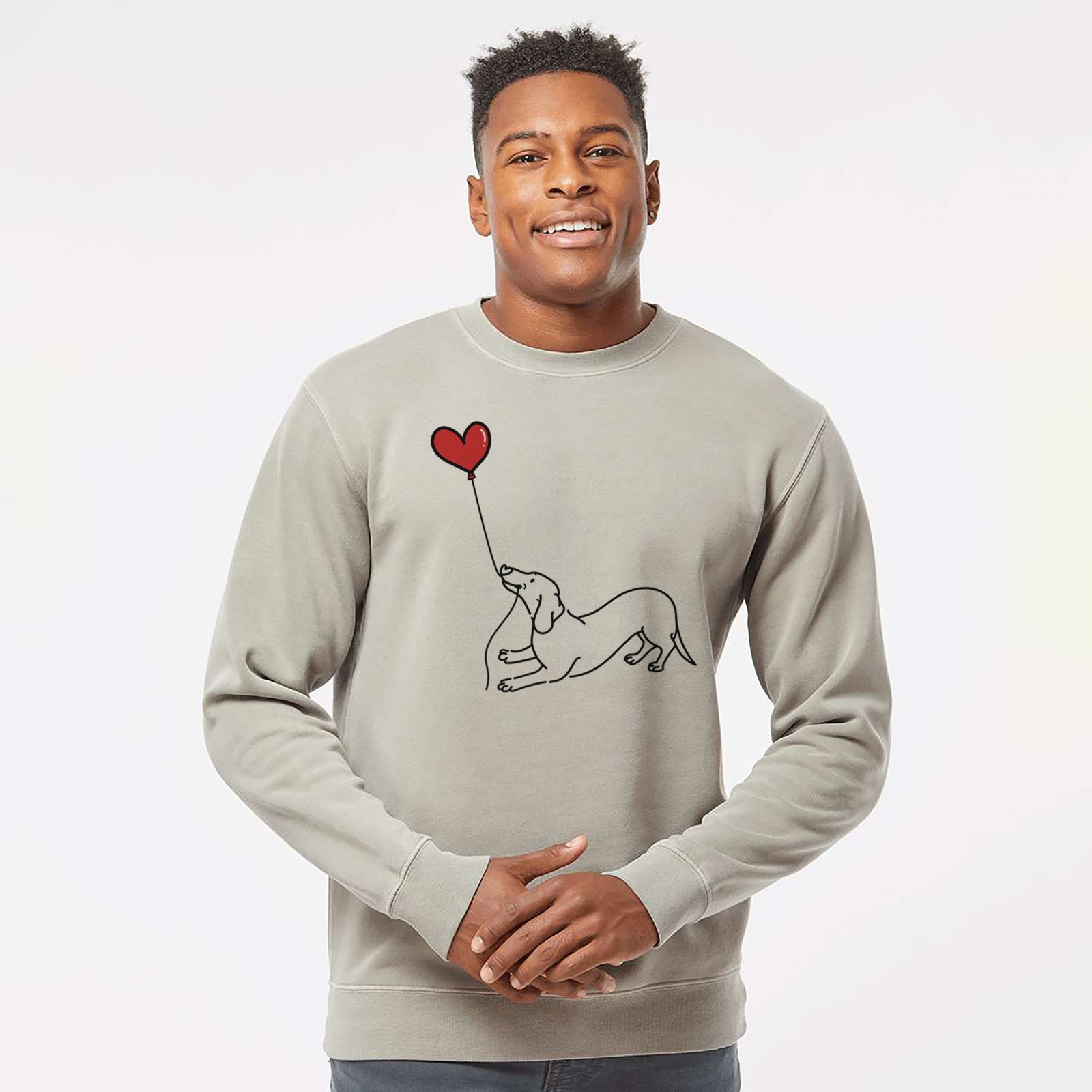 Minimalist line drawing of a Dachshund Heart String holding a heart balloon on a Cement Unisex pigment dyed crew sweatshirt