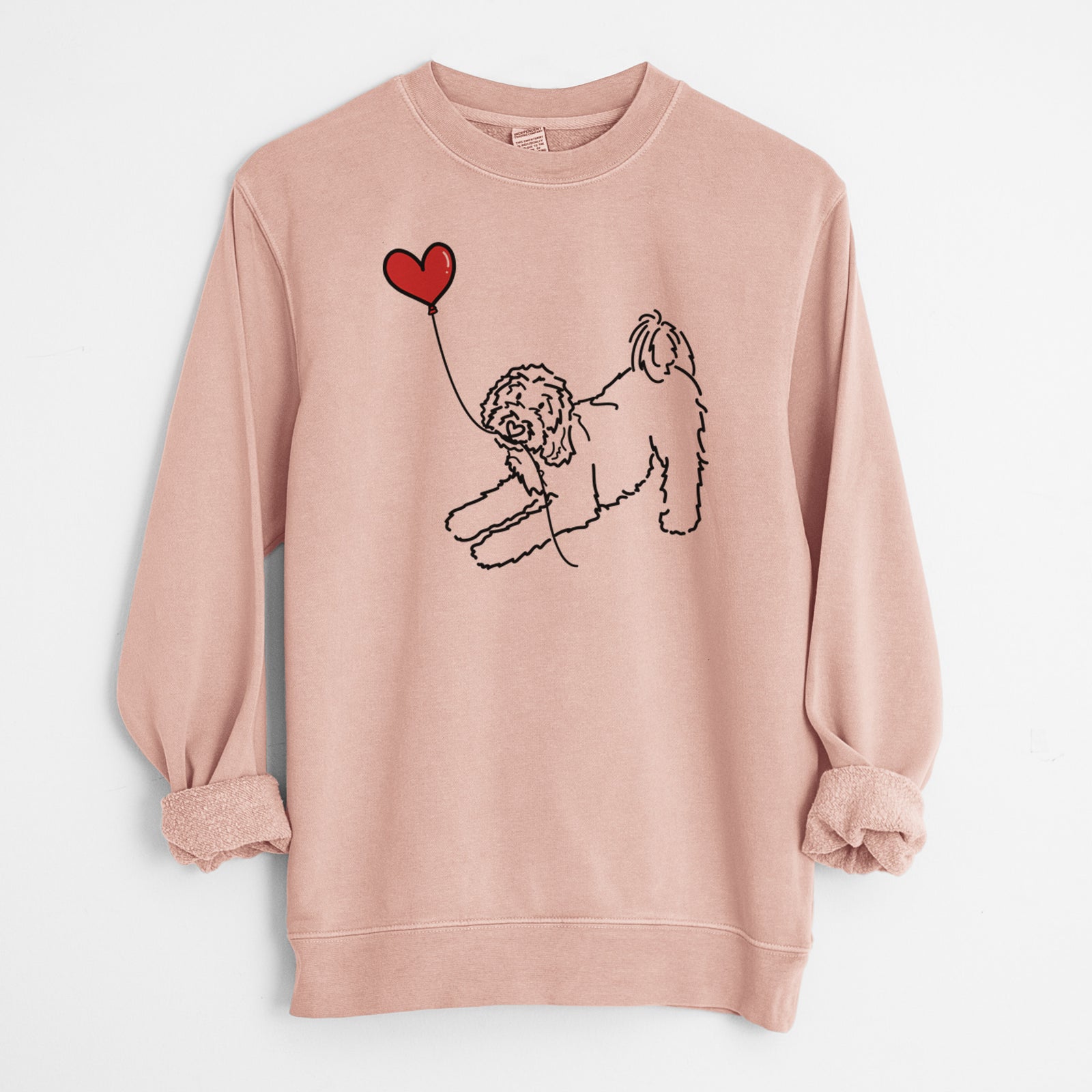 Minimalist line drawing of a Goldendoodle Heart String holding a heart balloon on a Dusty Pink Unisex pigment dyed crew sweatshirt