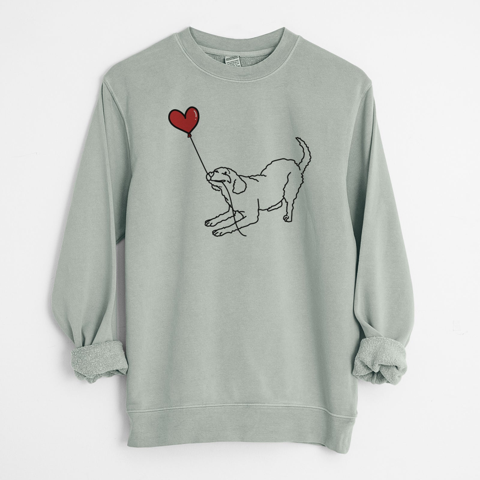 Minimalist line drawing of a Labradoodle Heart String holding a heart balloon on a Sage Unisex pigment dyed crew sweatshirt