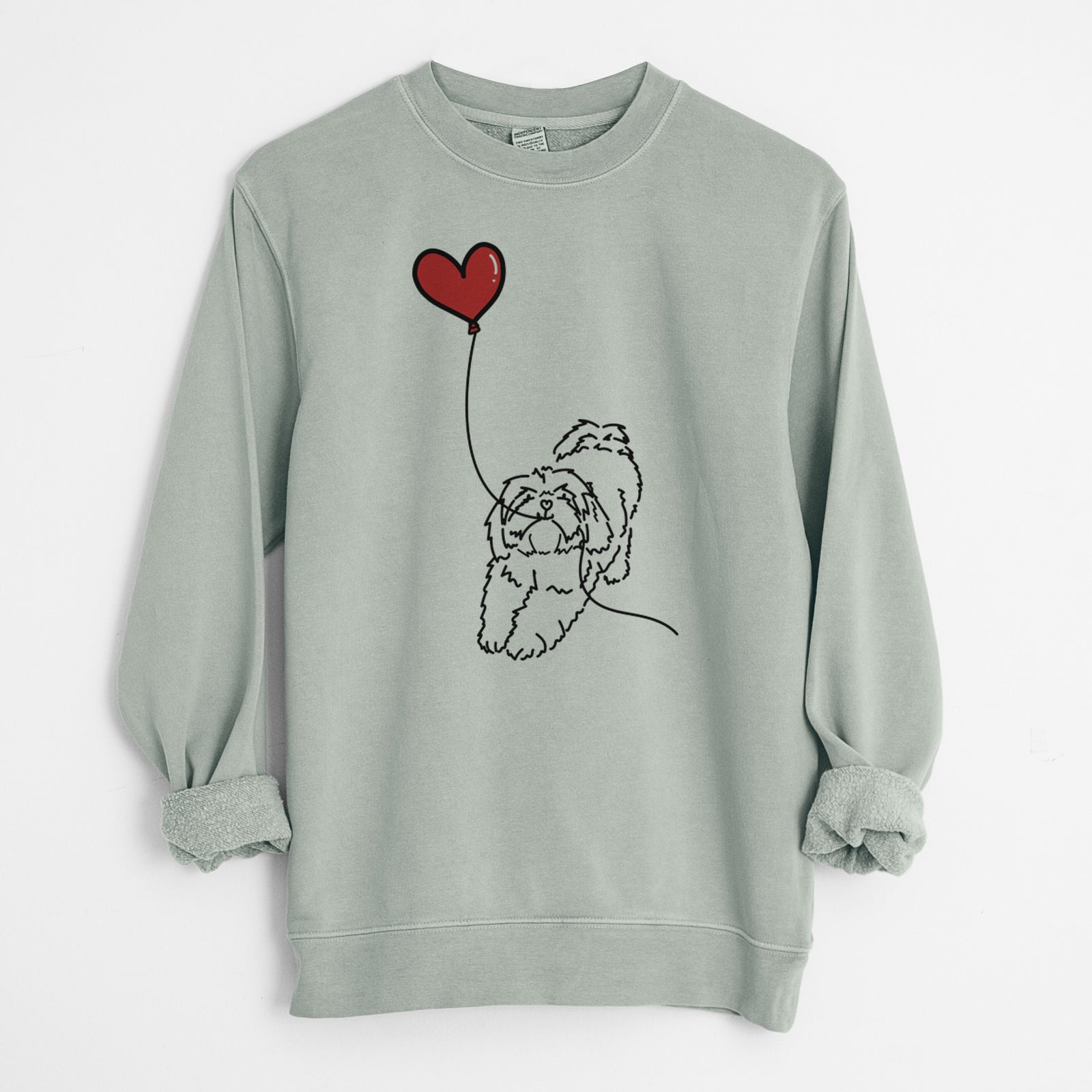 Minimalist line drawing of a Lhasa Apso Heart String holding a heart balloon on a Sage Unisex pigment dyed crew sweatshirt