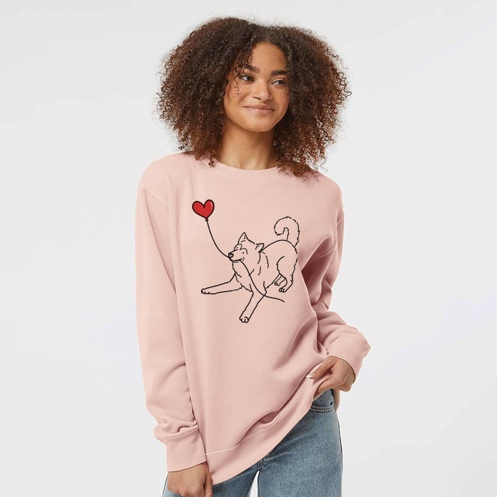 Minimalist line drawing of an Alaskan Malamute Heart String holding a heart balloon on a Dusty Pink Unisex pigment dyed crew sweatshirt