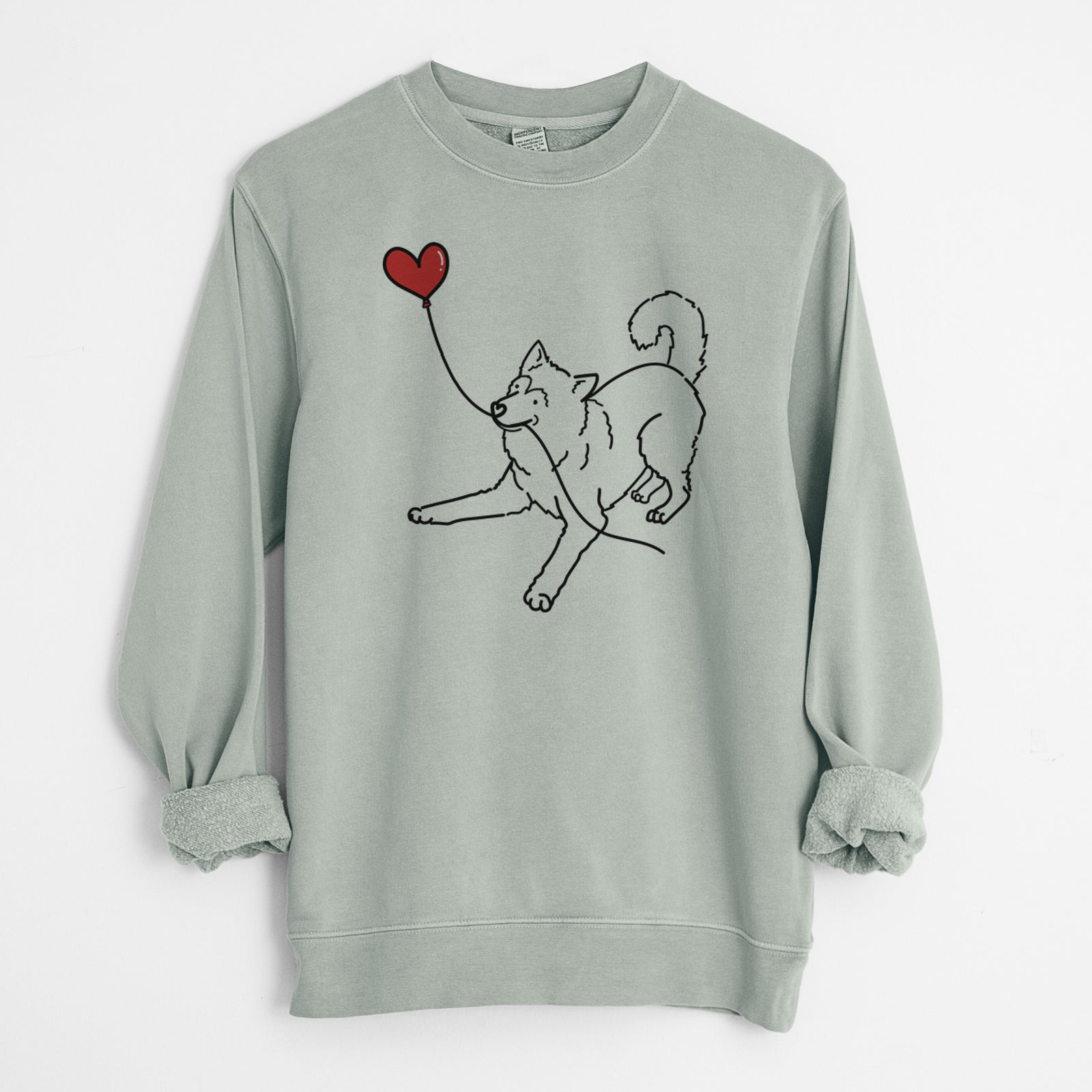 Minimalist line drawing of an Alaskan Malamute Heart String holding a heart balloon on a Sage Unisex pigment dyed crew sweatshirt