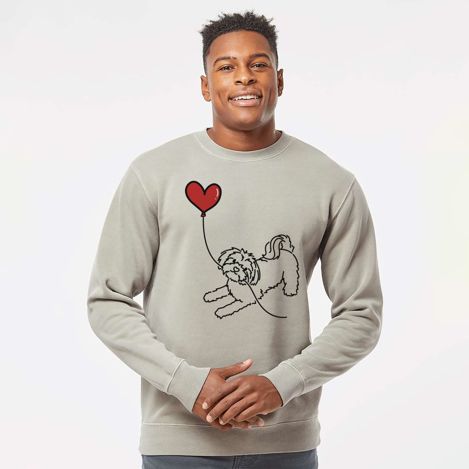 Minimalist line drawing of a Maltese Heart String holding a heart balloon on a Cement Unisex pigment dyed crew sweatshirt
