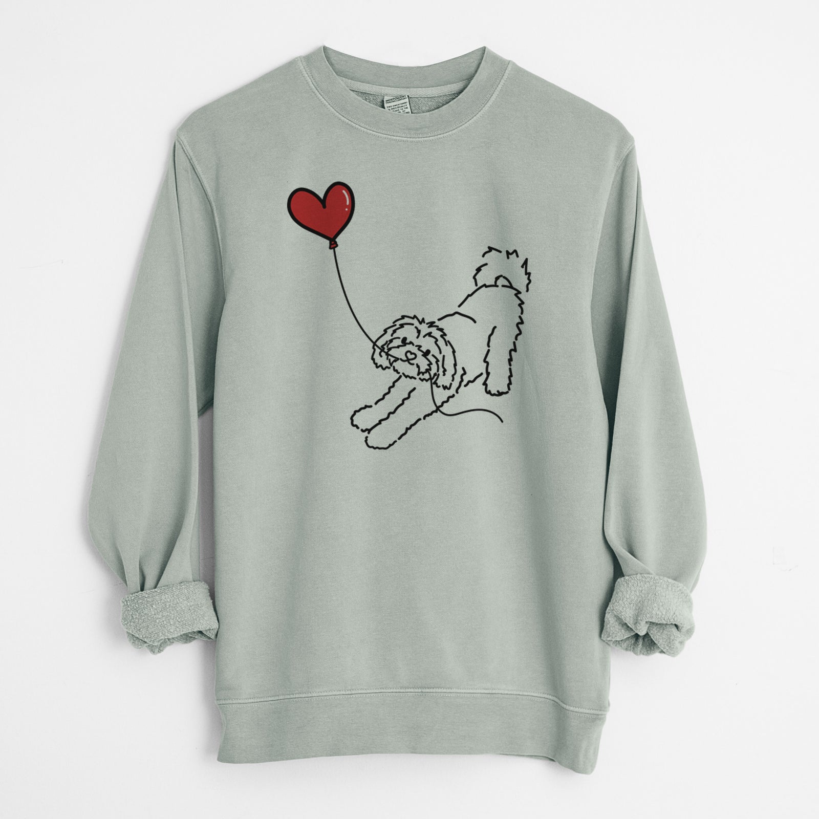 Minimalist line drawing of a Maltipoo Heart String holding a heart balloon on a Sage Unisex pigment dyed crew sweatshirt
