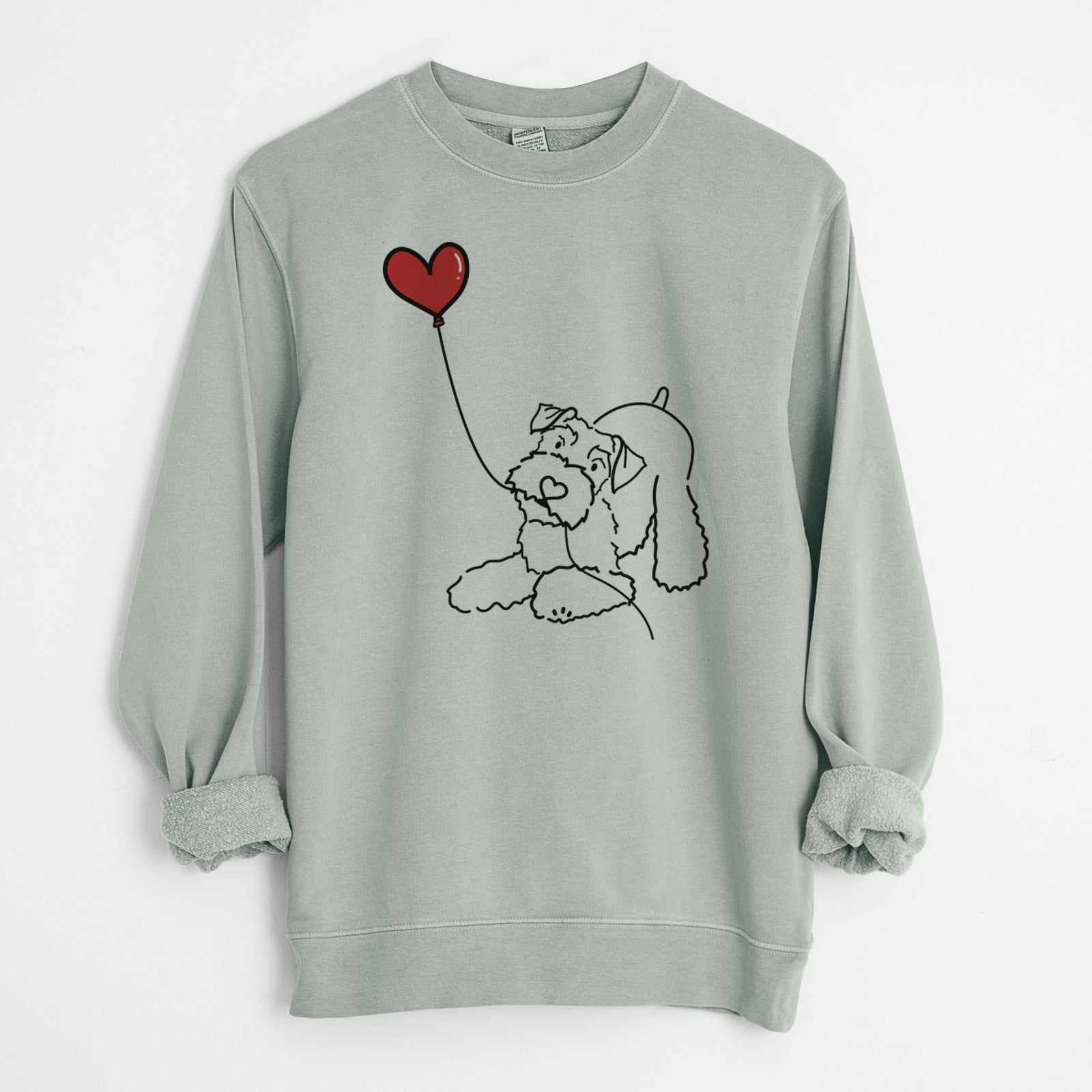 Minimalist line drawing of a Mini Schnauzer Heart String holding a heart balloon on a Sage Unisex pigment dyed crew sweatshirt