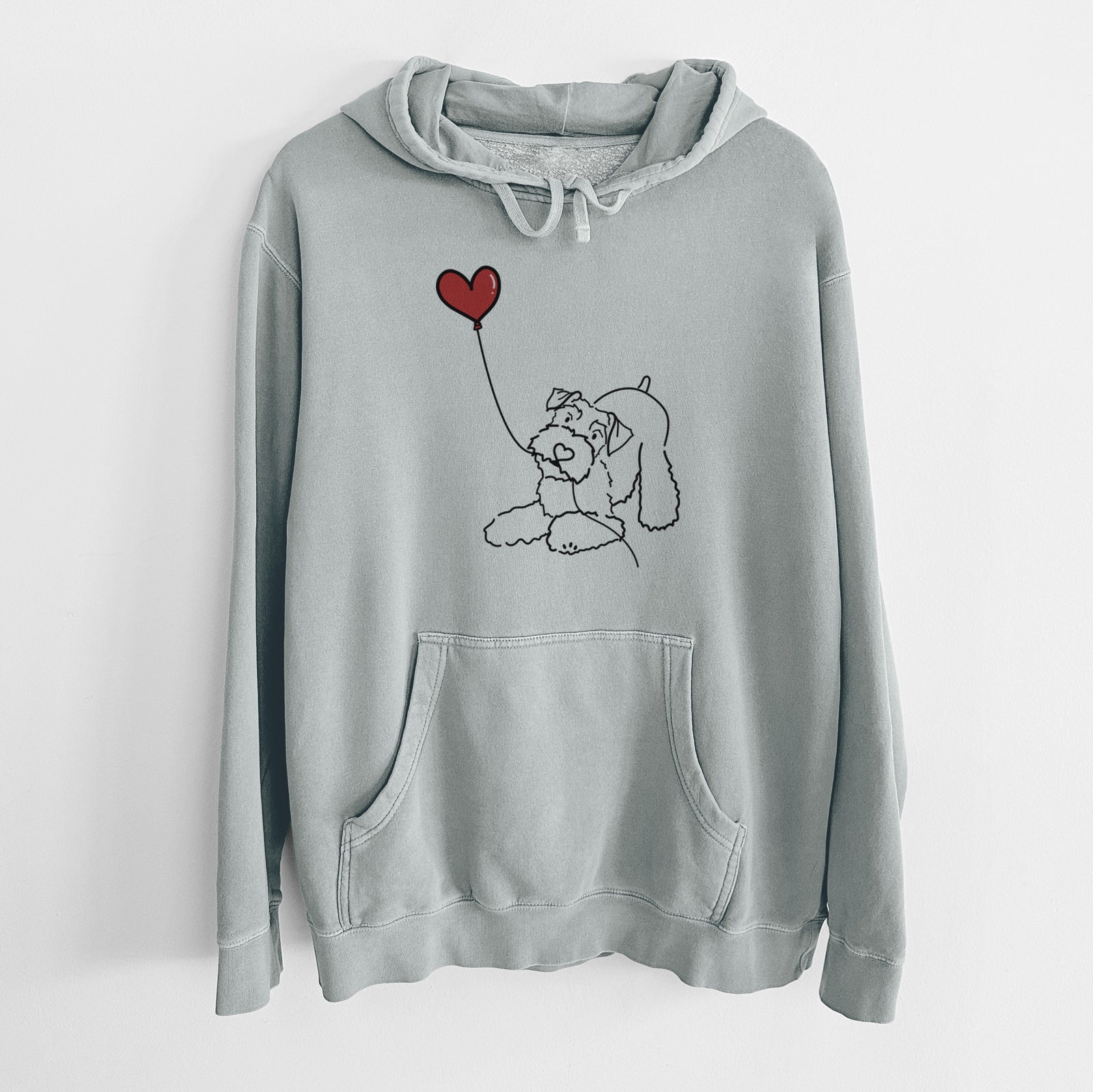 Minimalist line drawing of a Mini Schnauzer Heart String holding a heart balloon on a Sage Unisex pigment dyed hoodie