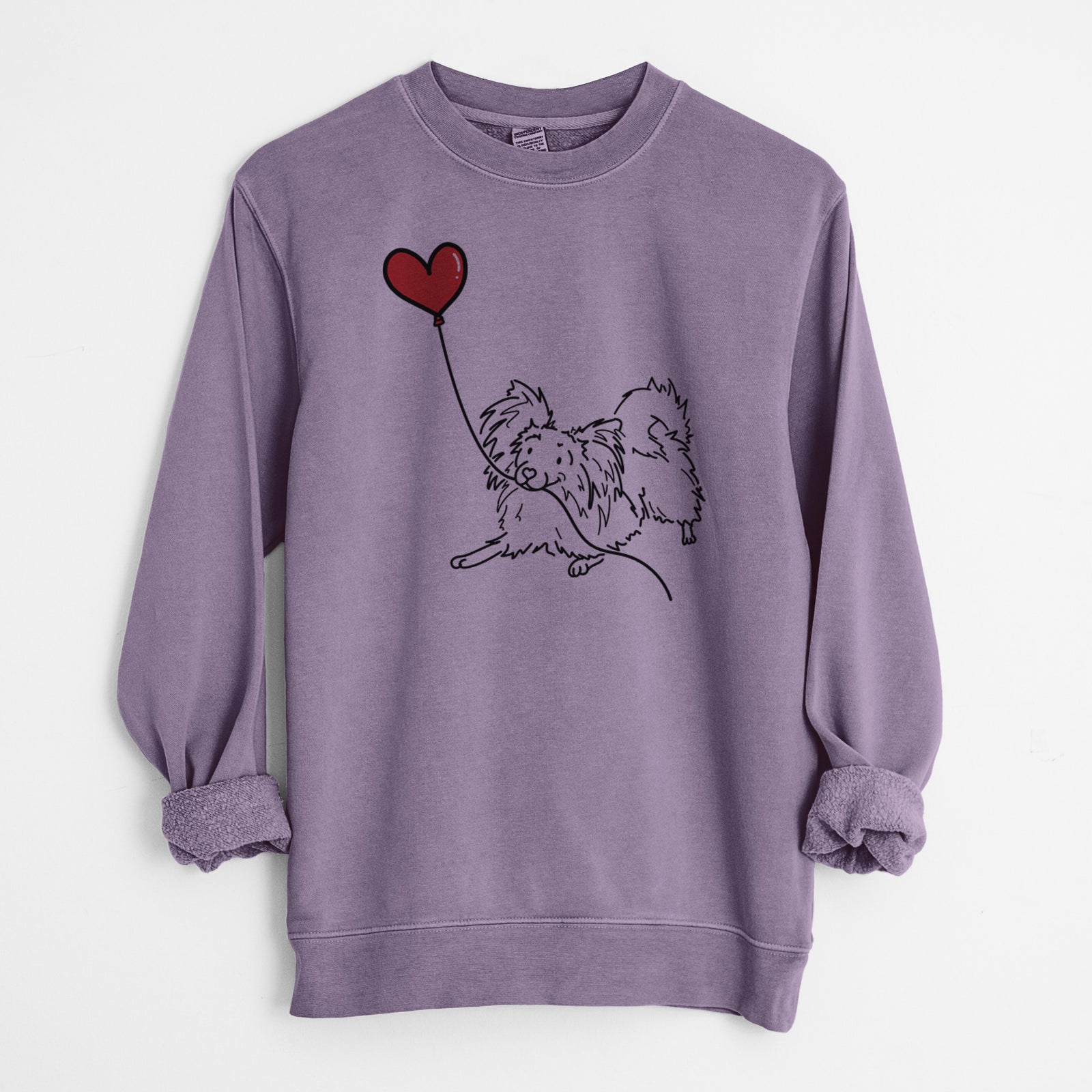 Minimalist line drawing of a Papillon Heart String holding a heart balloon on a Plum Unisex pigment dyed crew sweatshirt