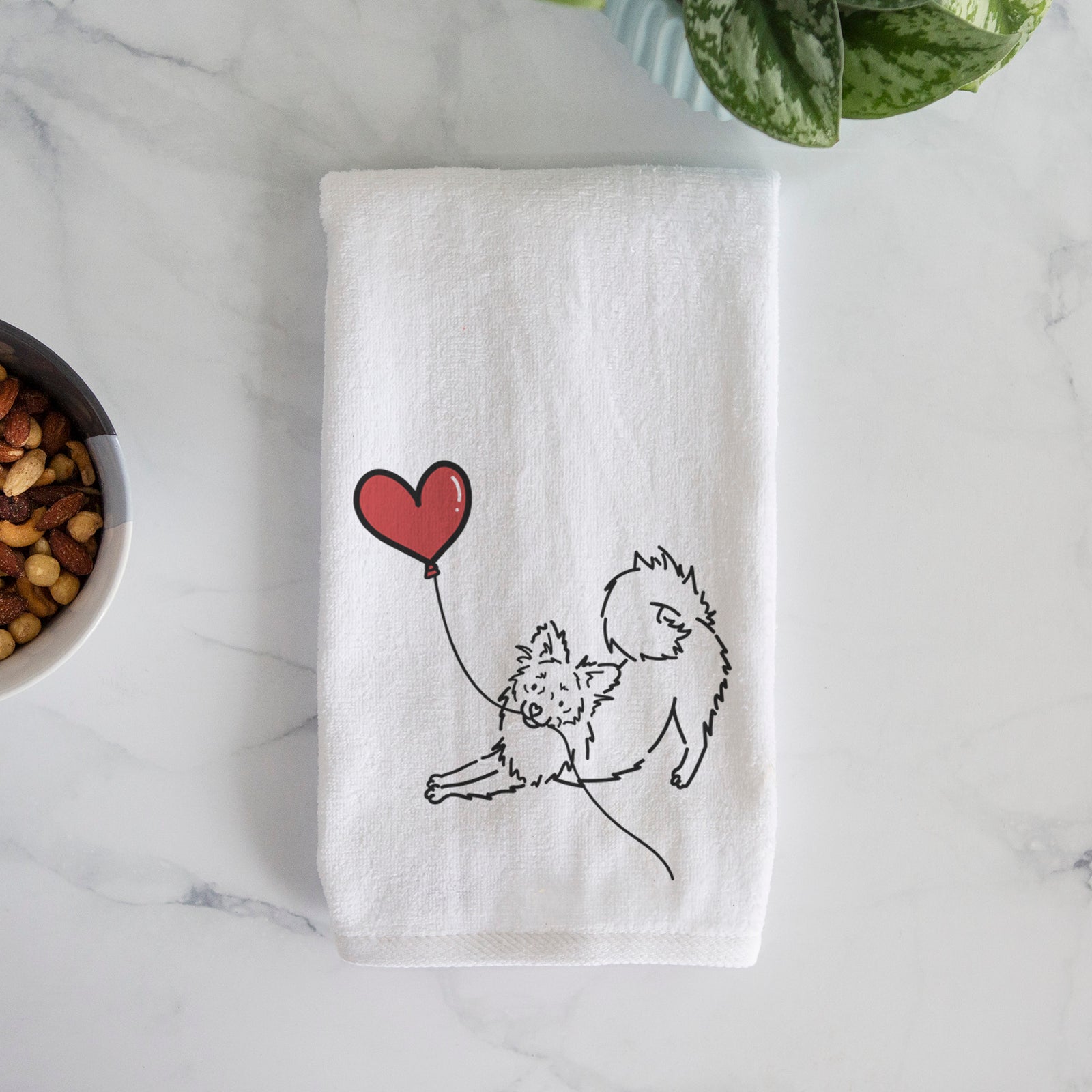 Minimalist line drawing of a Pomchi Heart String holding a heart balloon on a hand towel
