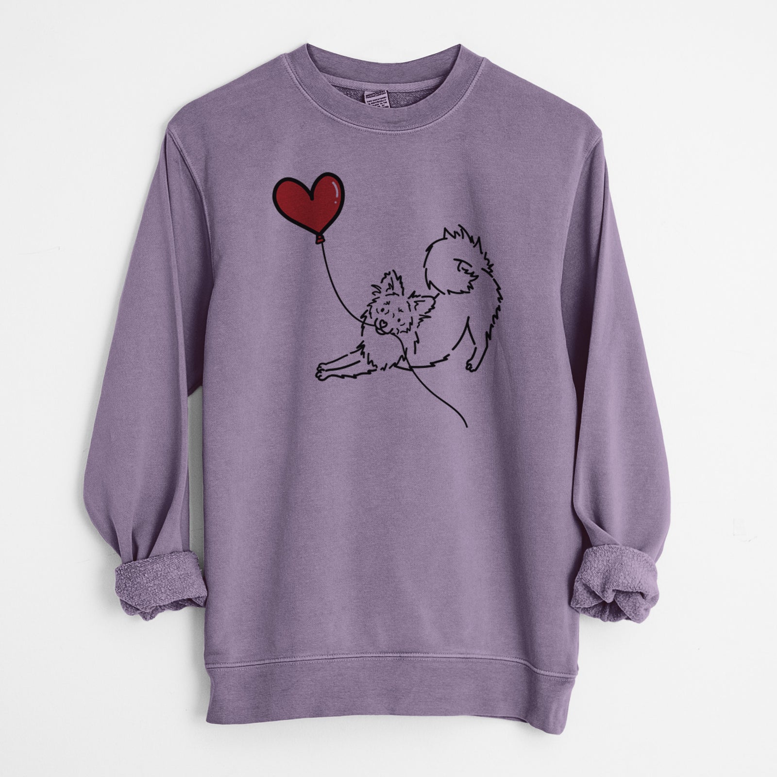 Minimalist line drawing of a Pomchi Heart String holding a heart balloon on a Plum Unisex pigment dyed crew sweatshirt