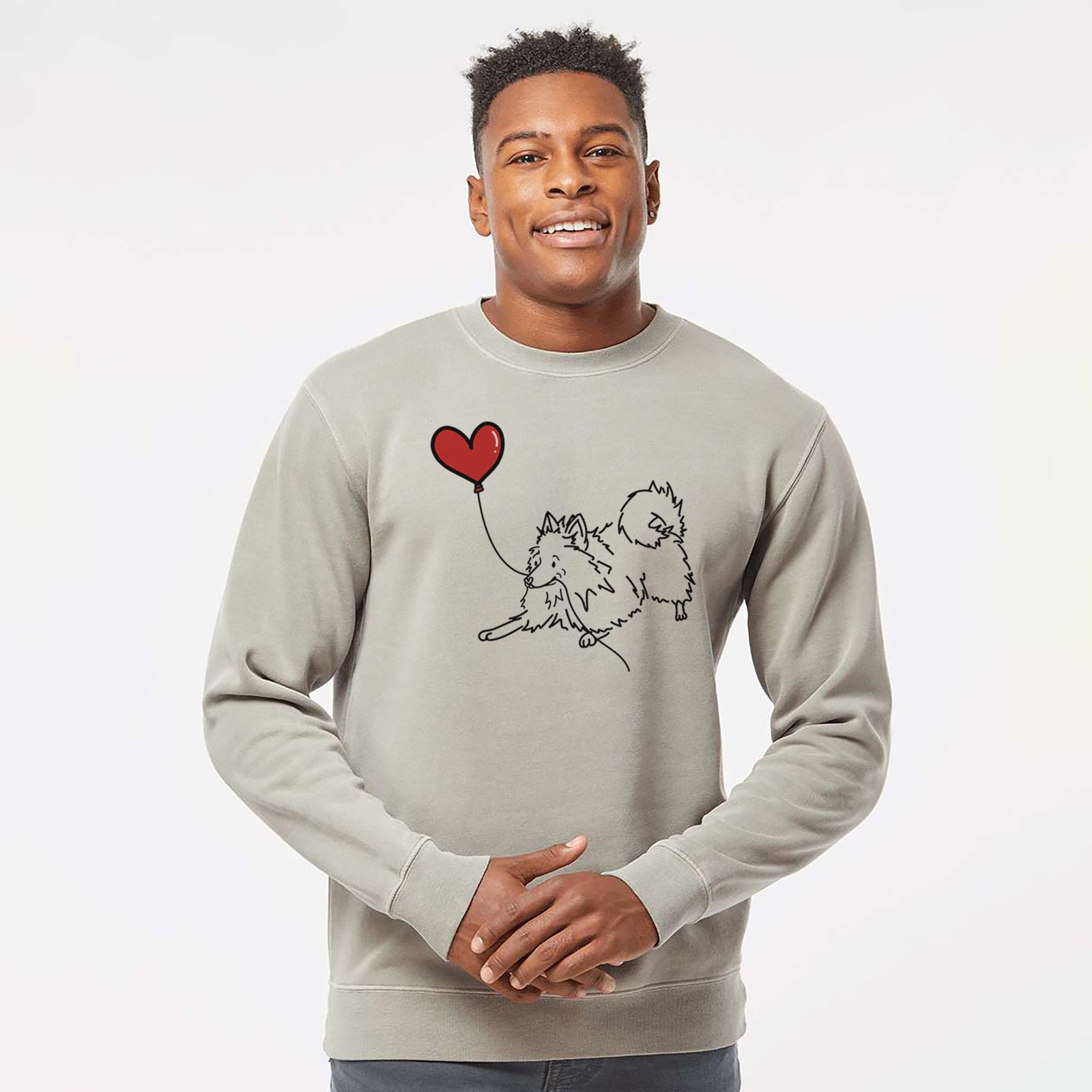 Minimalist line drawing of a Pomeranian Heart String holding a heart balloon on a Cement Unisex pigment dyed crew sweatshirt