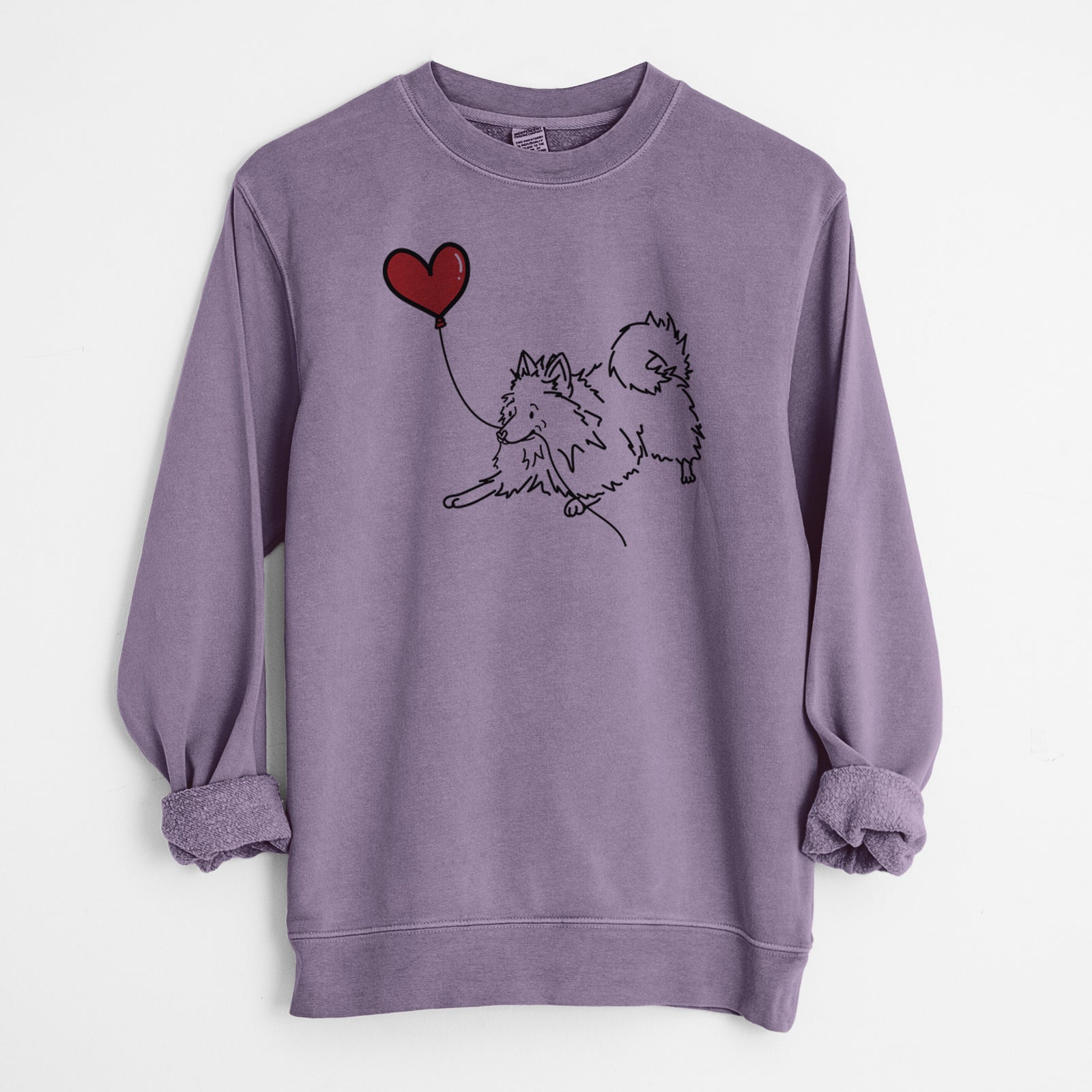 Minimalist line drawing of a Pomeranian Heart String holding a heart balloon on a Plum Unisex pigment dyed crew sweatshirt