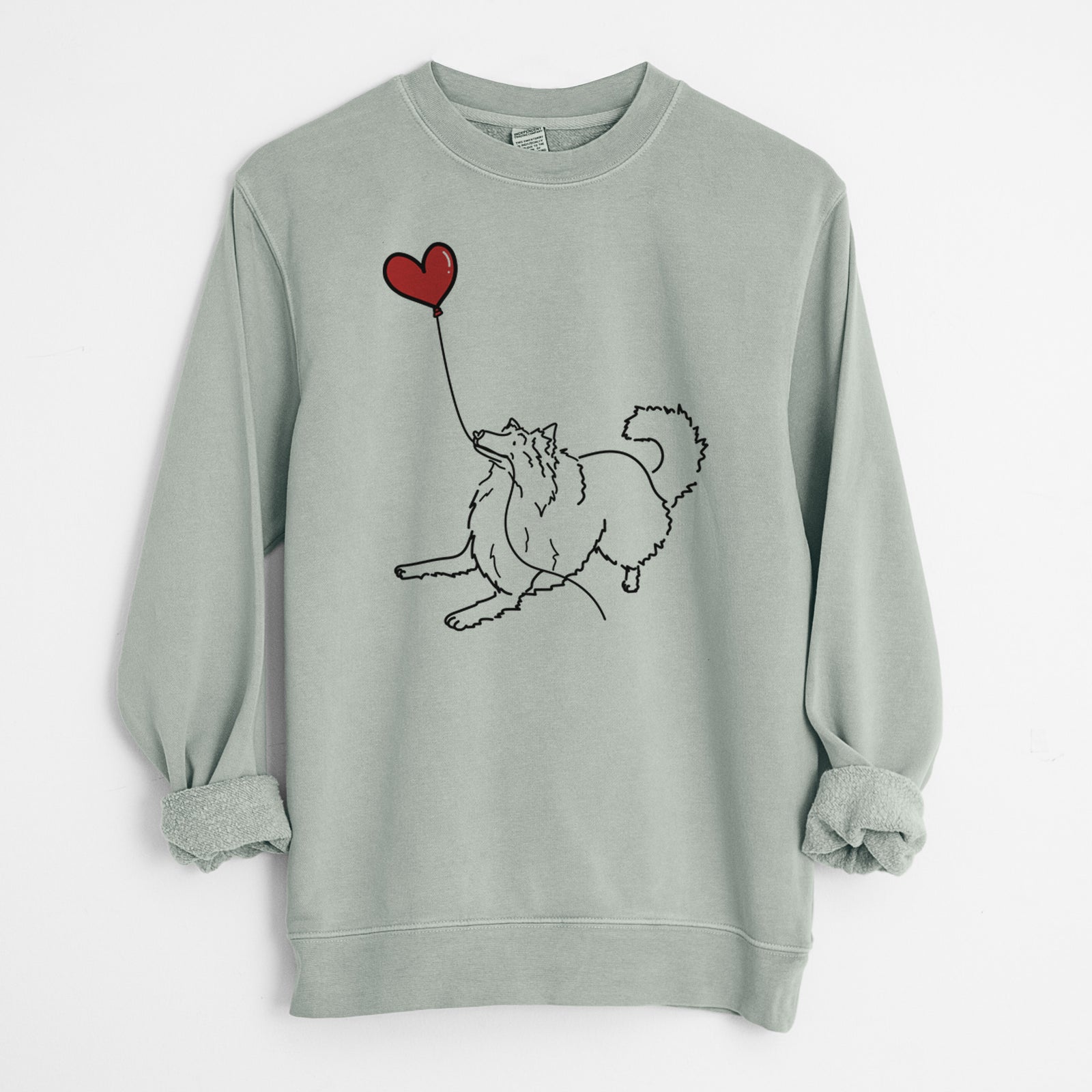 Minimalist line drawing of a Rough Collie Heart String holding a heart balloon on a Sage Unisex pigment dyed crew sweatshirt