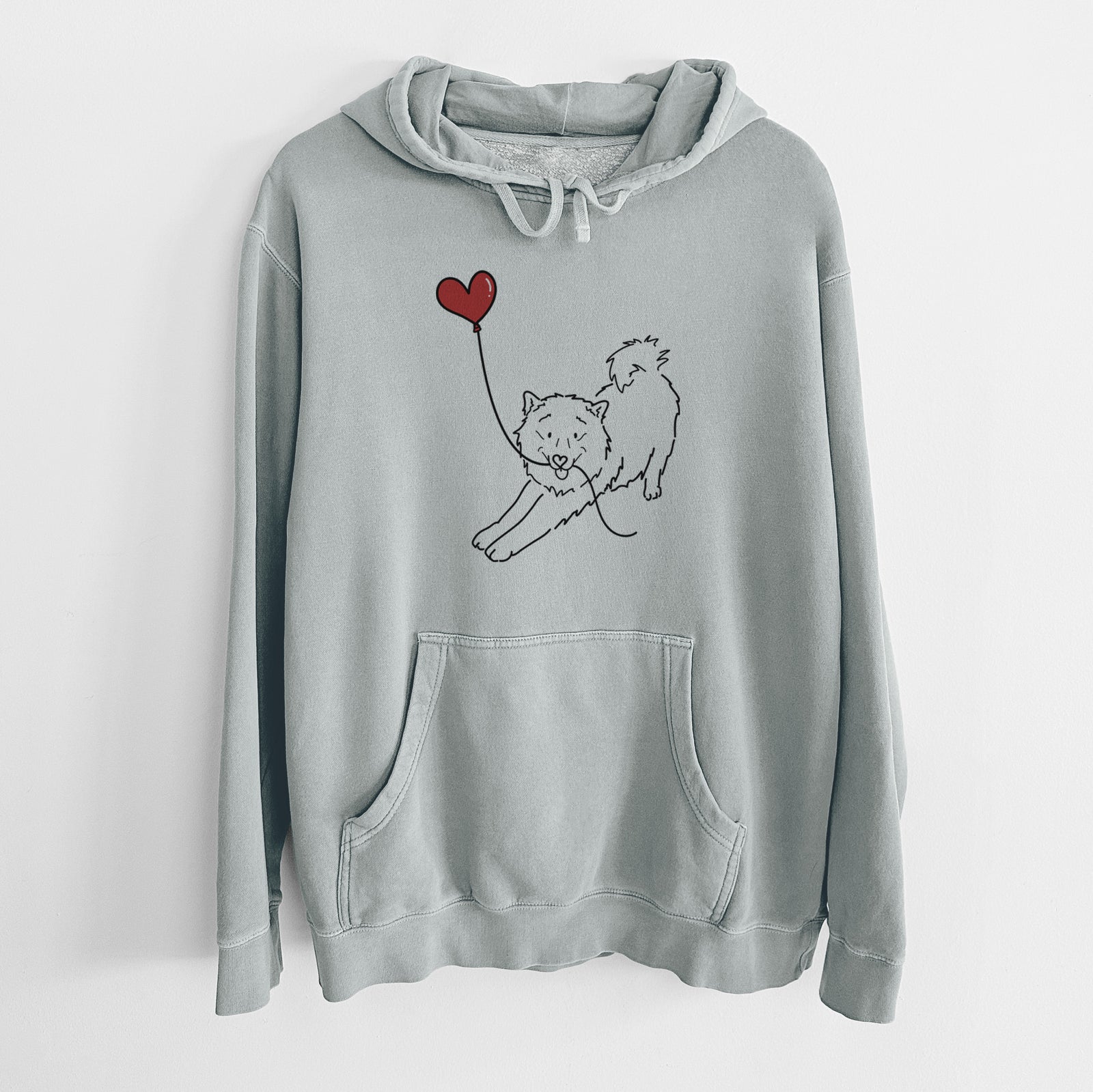 Minimalist line drawing of a Samoyed Heart String holding a heart balloon on a Sage Unisex pigment dyed hoodie