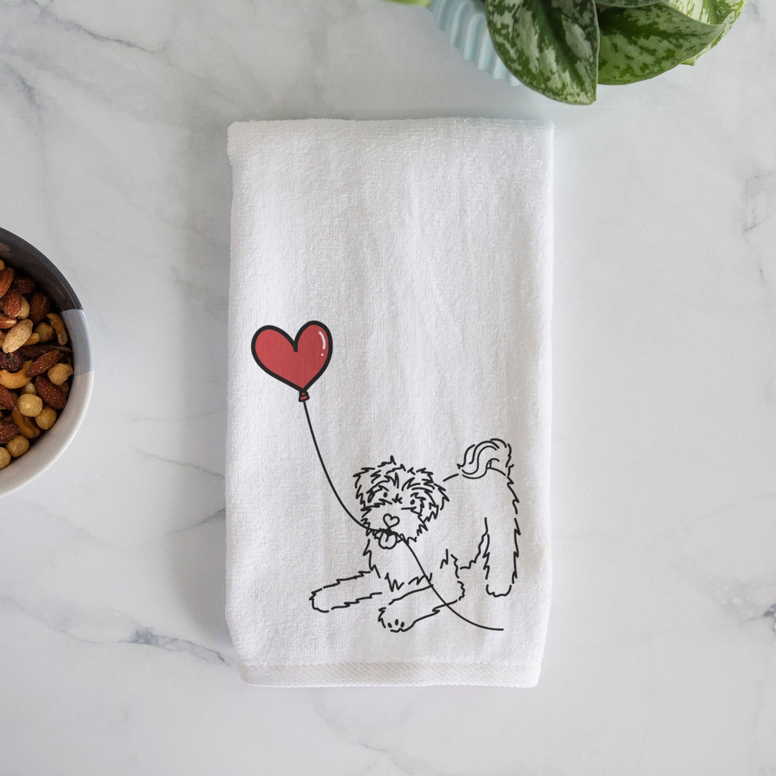 Minimalist line drawing of a Schnoodle Heart String holding a heart balloon on a hand towel