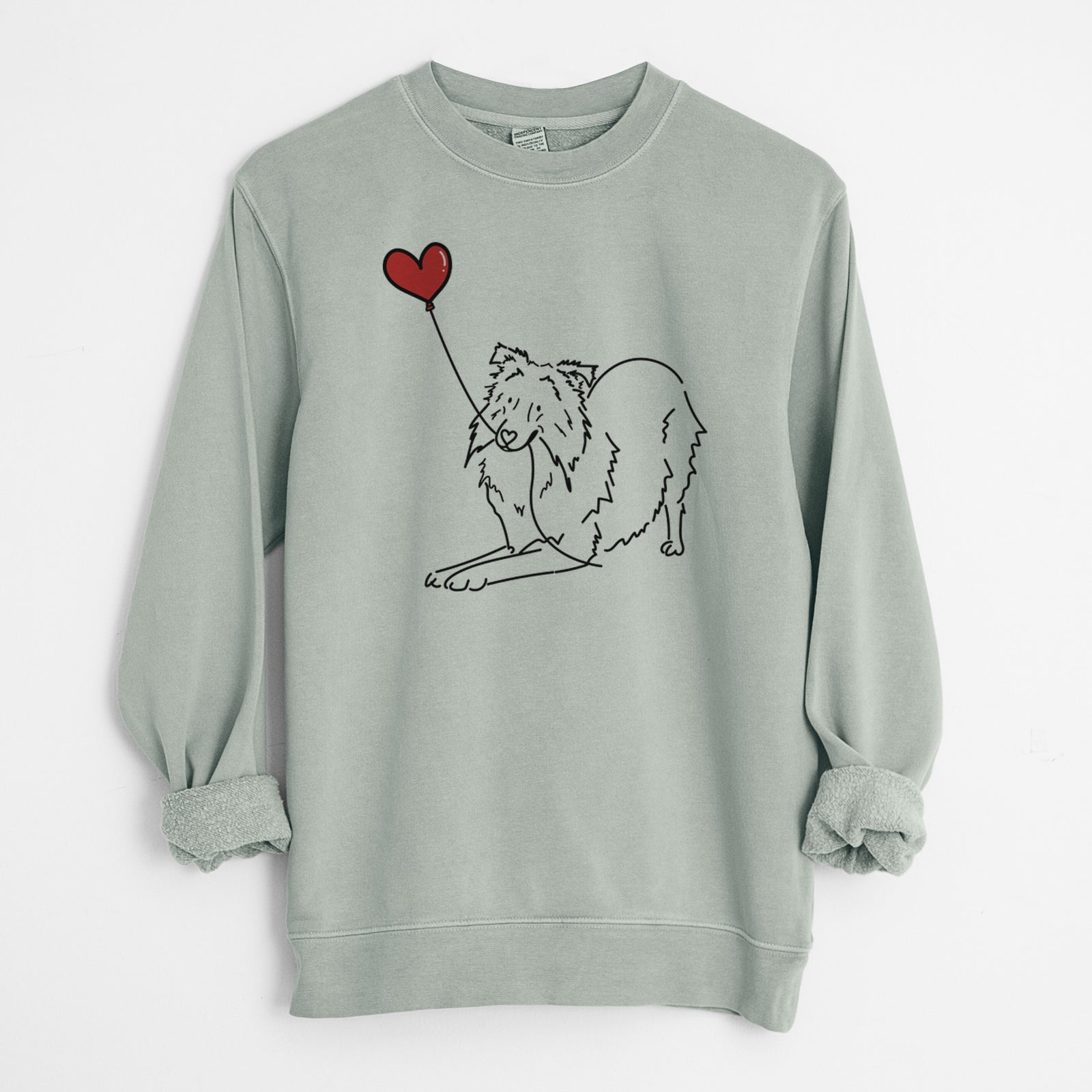 Minimalist line drawing of a Shetland Sheepdog Heart String holding a heart balloon on a Sage Unisex pigment dyed crew sweatshirt
