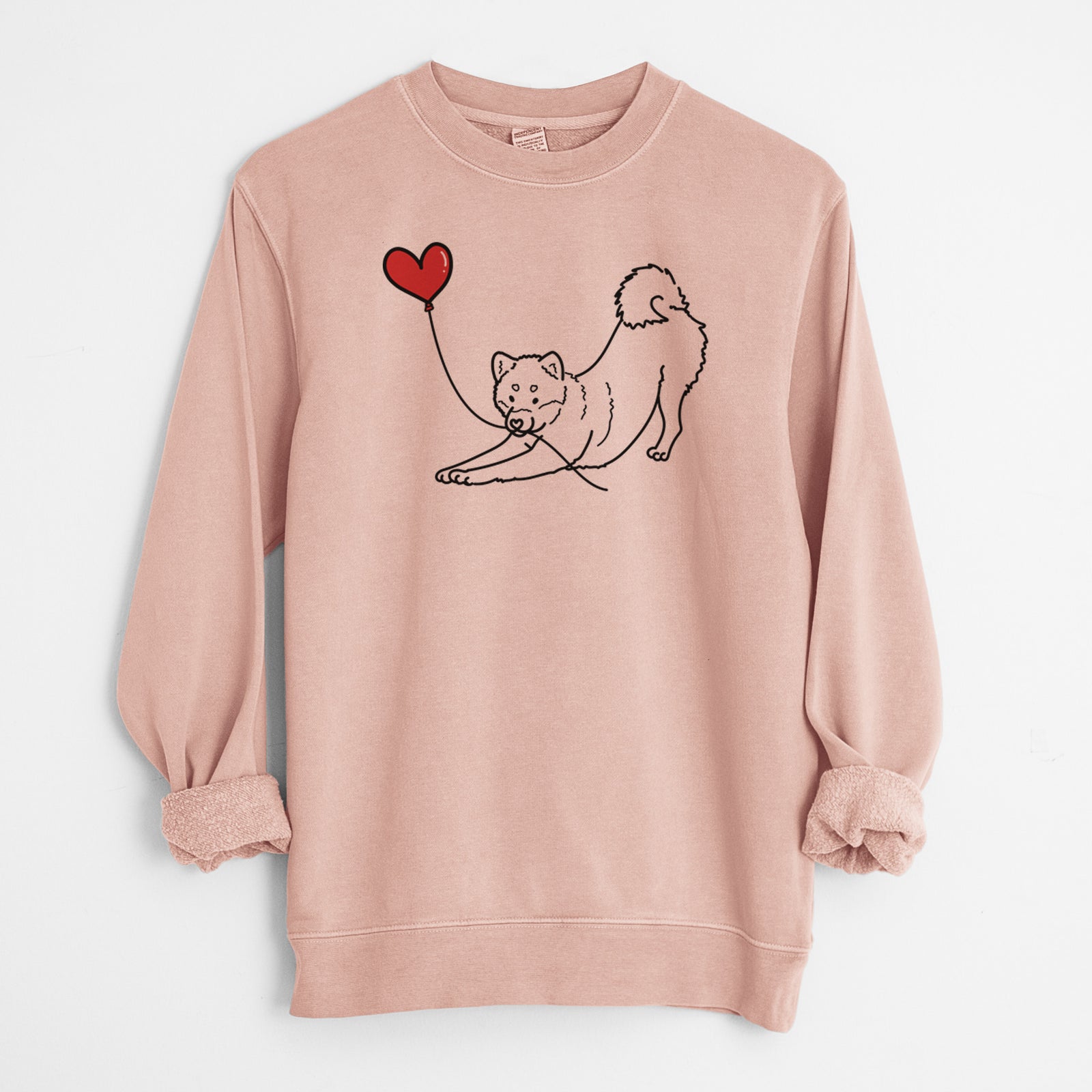 Minimalist line drawing of a Shiba Inu Heart String holding a heart balloon on a Dusty Pink Unisex pigment dyed crew sweatshirt