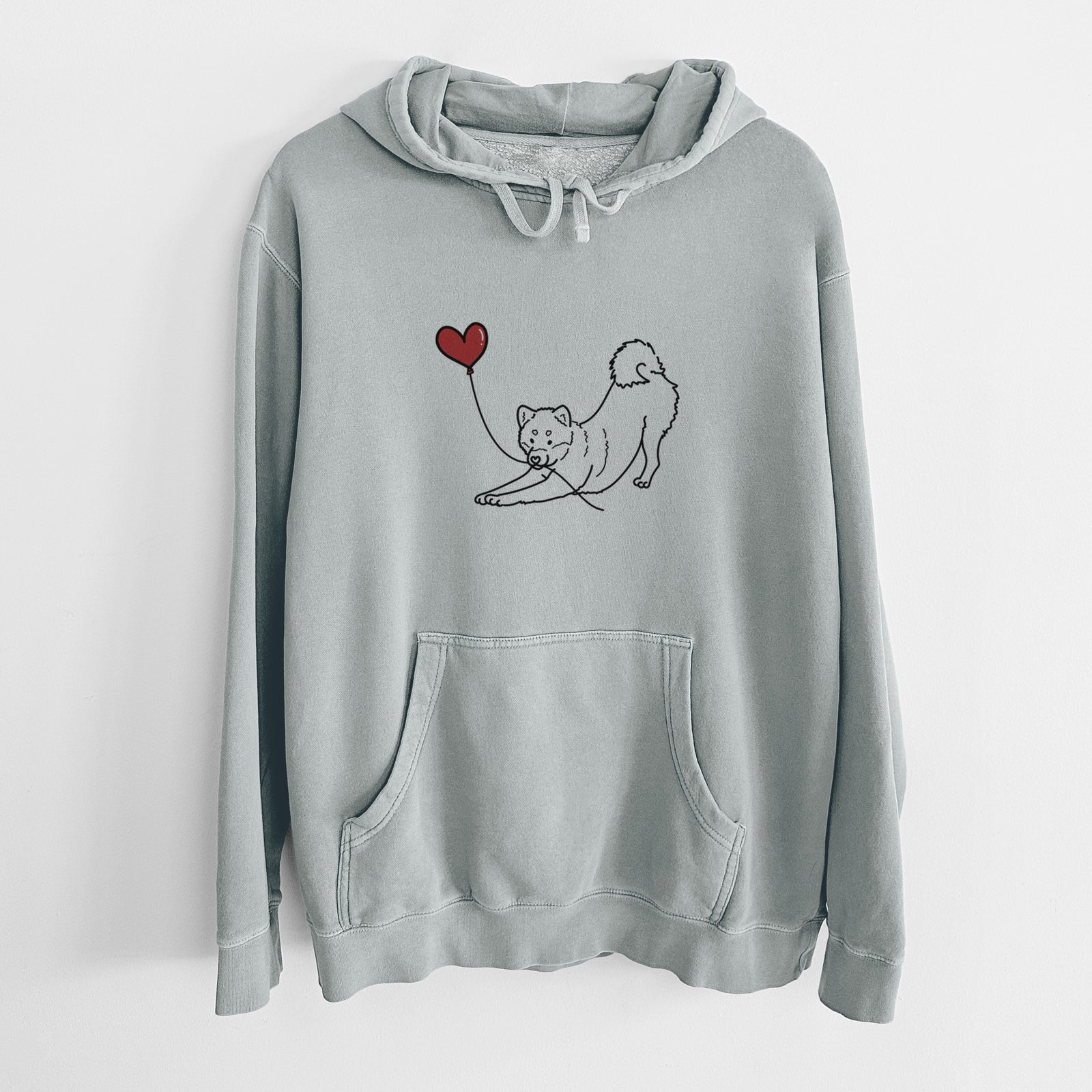 Minimalist line drawing of a Shiba Inu Heart String holding a heart balloon on a Sage Unisex pigment dyed hoodie