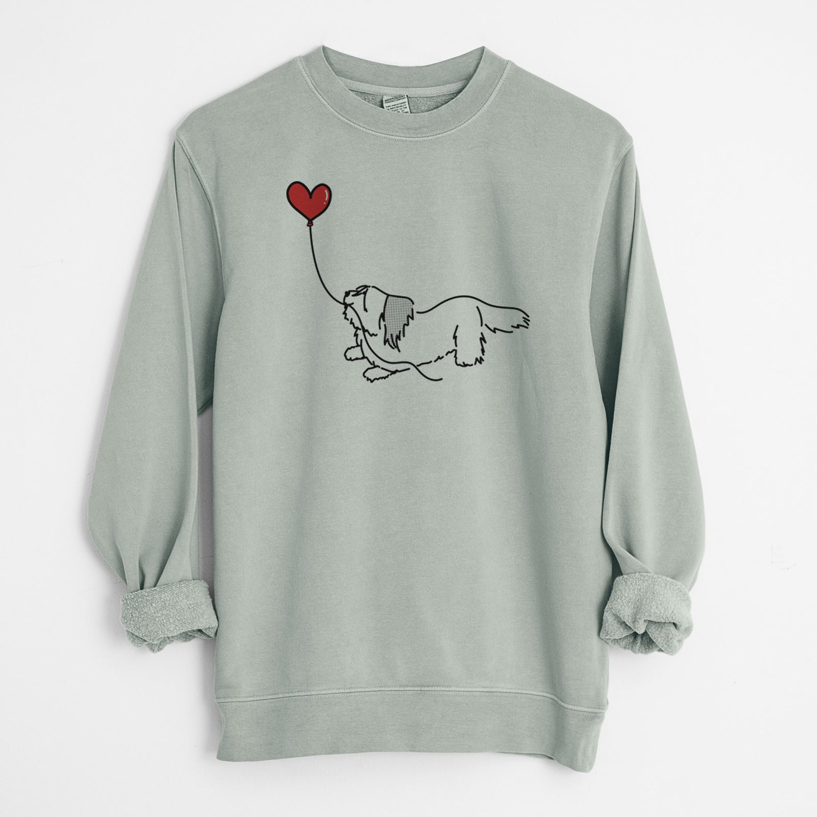 Minimalist line drawing of a Skye Terrier Heart String holding a heart balloon on a Sage Unisex pigment dyed crew sweatshirt