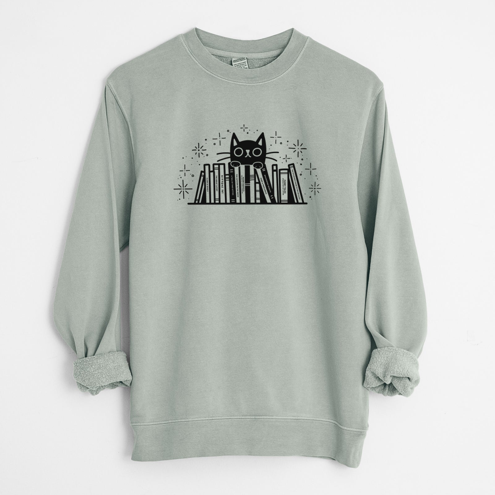 'Kitty Library - Black Cat Behind Books' design on a Sage Unisex pigment dyed crew sweatshirt