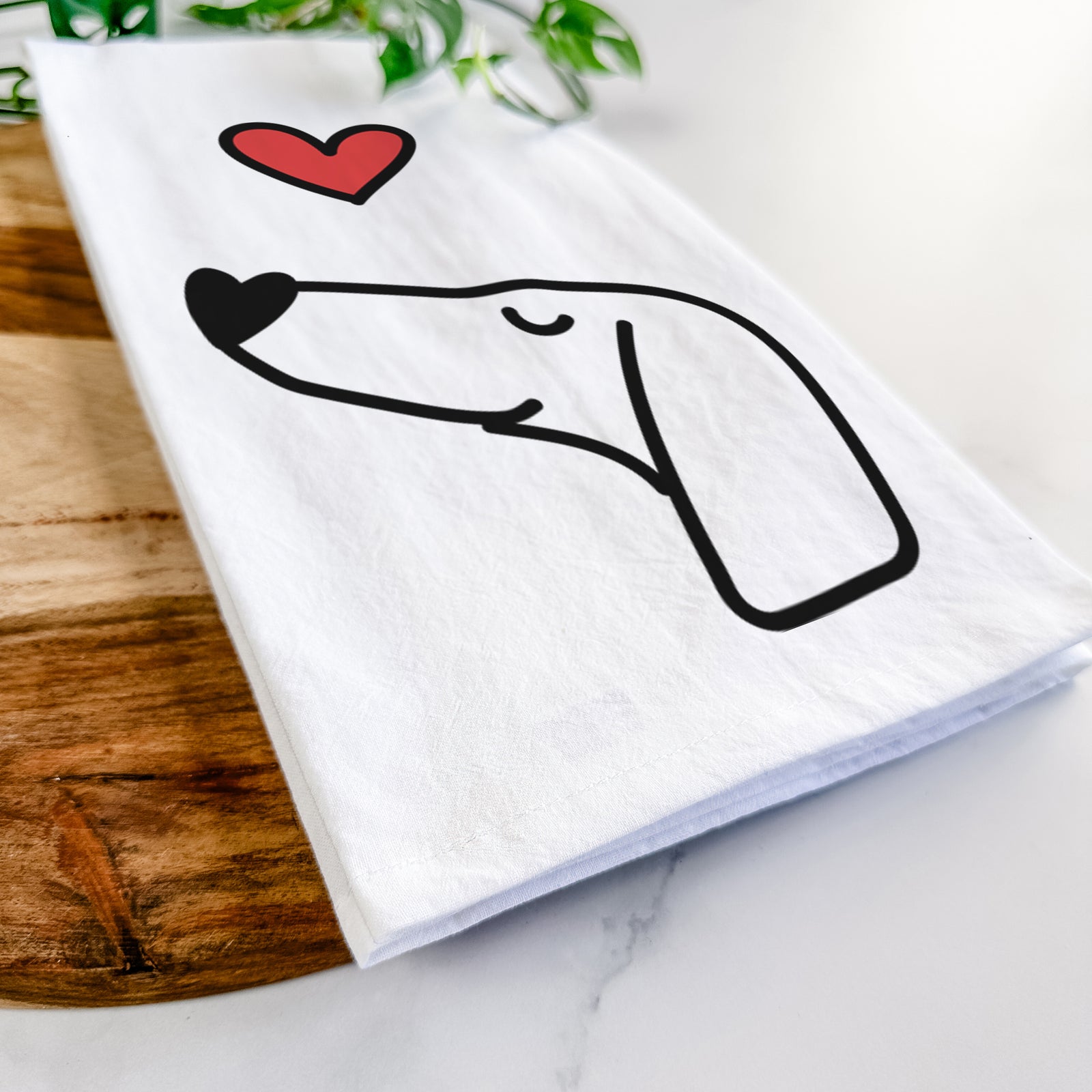 Minimalist line drawing of a Dachshund with a red heart on a tea towel