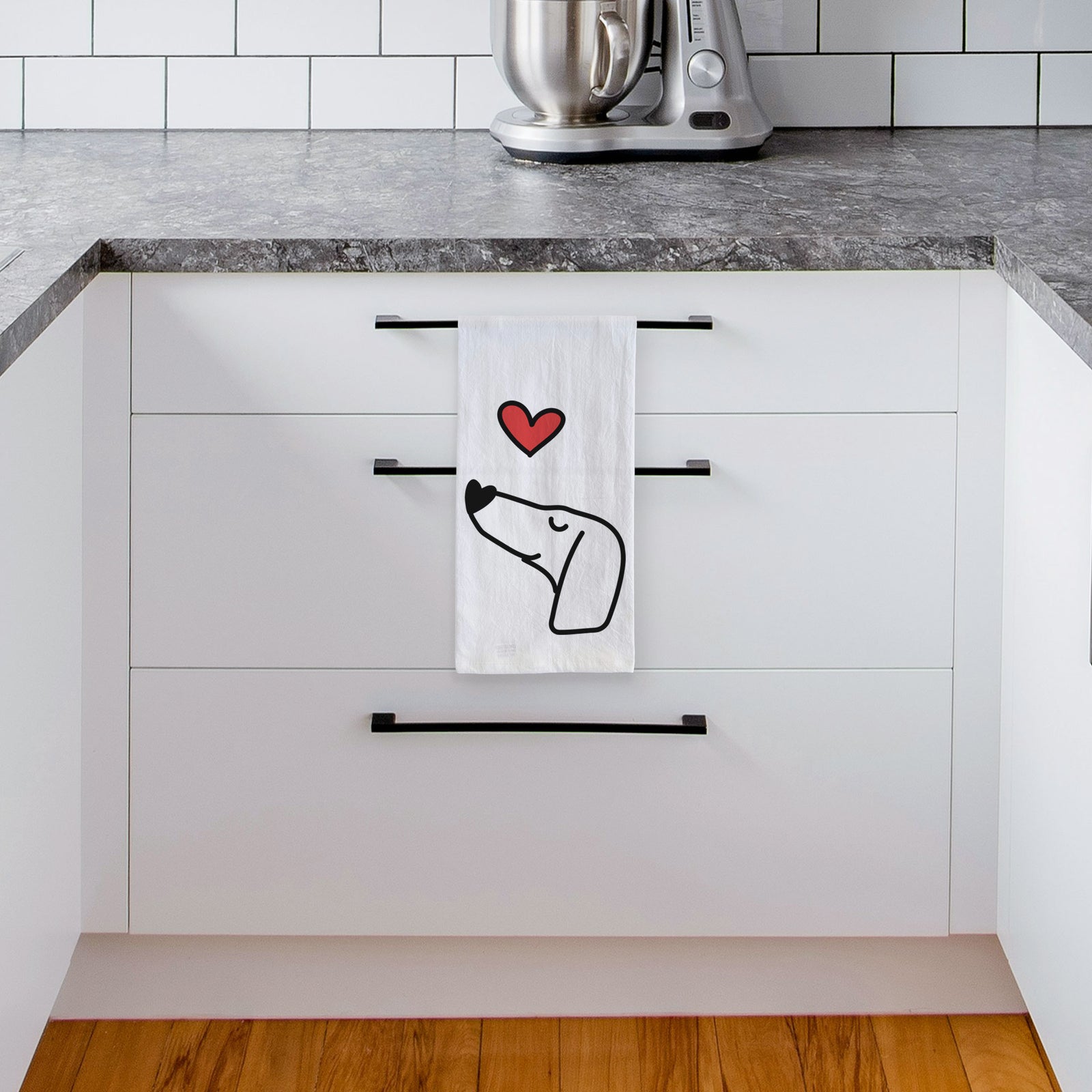 Minimalist line drawing of a Dachshund with a red heart on a tea towel, hanging on an oven door in a kitchen