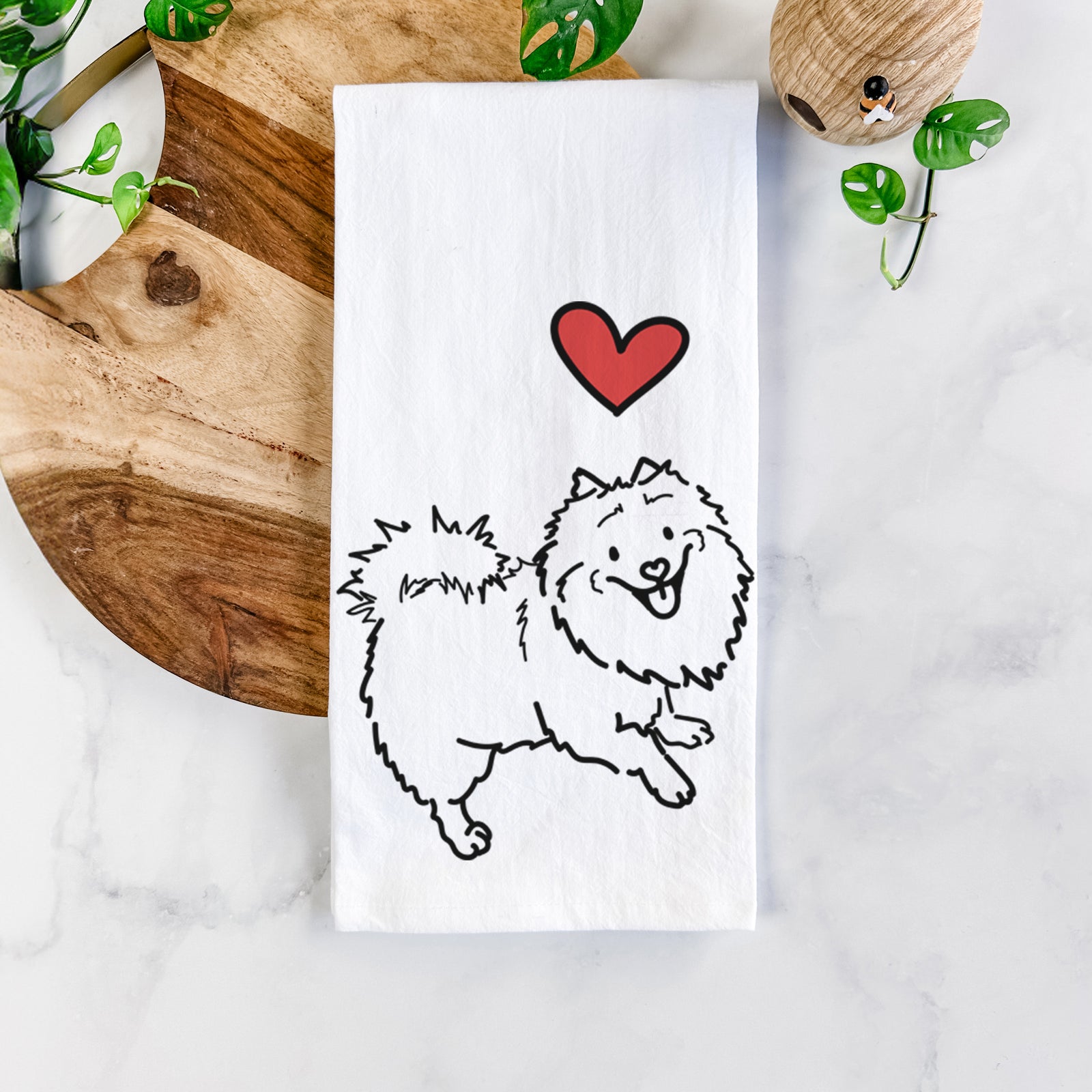 Minimalist line drawing of Goldie the Pomeranian Mix with a red heart on a tea towel