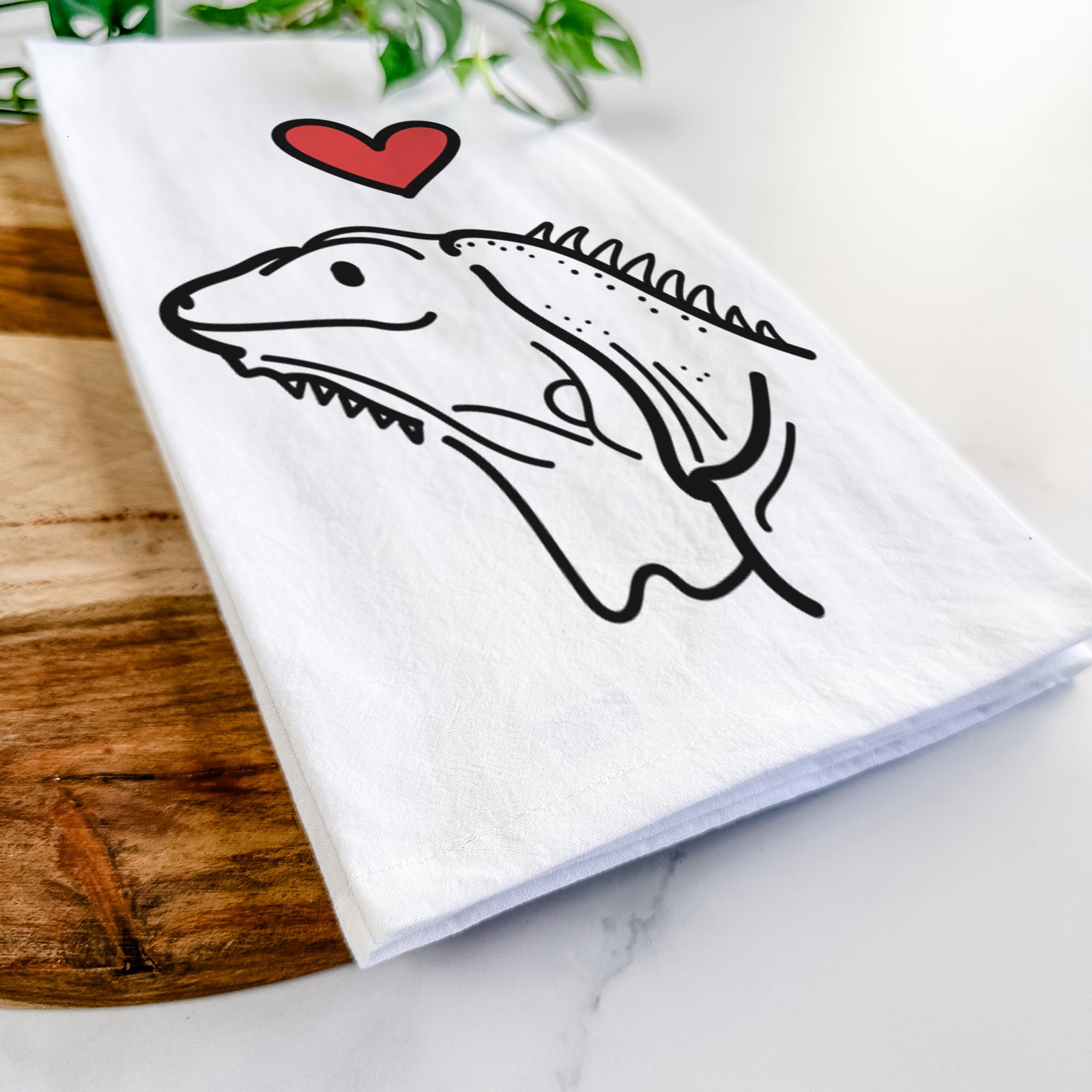 Minimalist line drawing of Louie the Iguana with a red heart on a tea towel