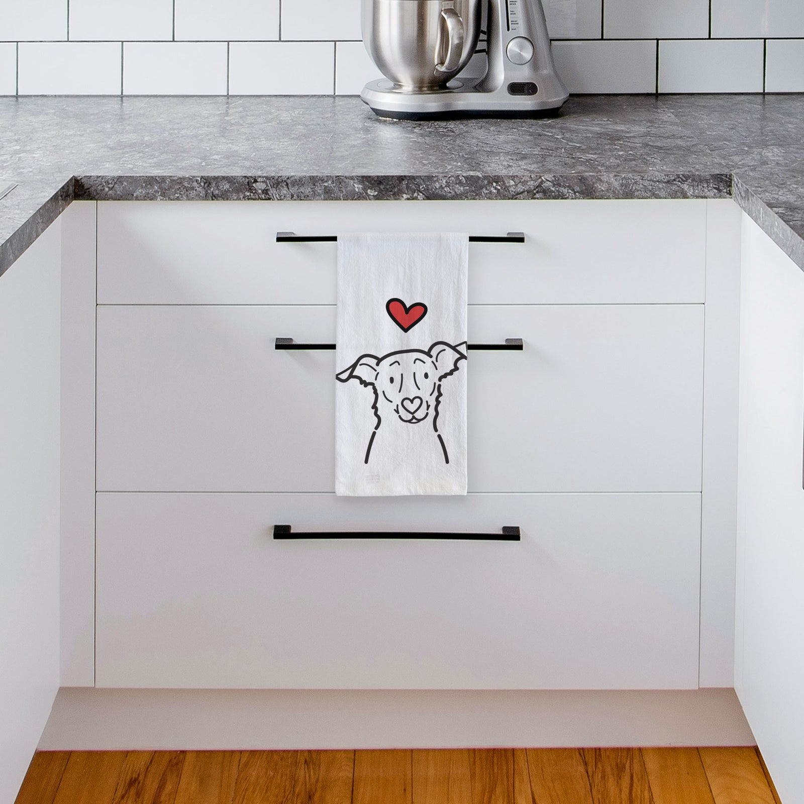 Minimalist line drawing of Millie the Border Collie Mix with a red heart on a tea towel, hanging on an oven door in a kitchen