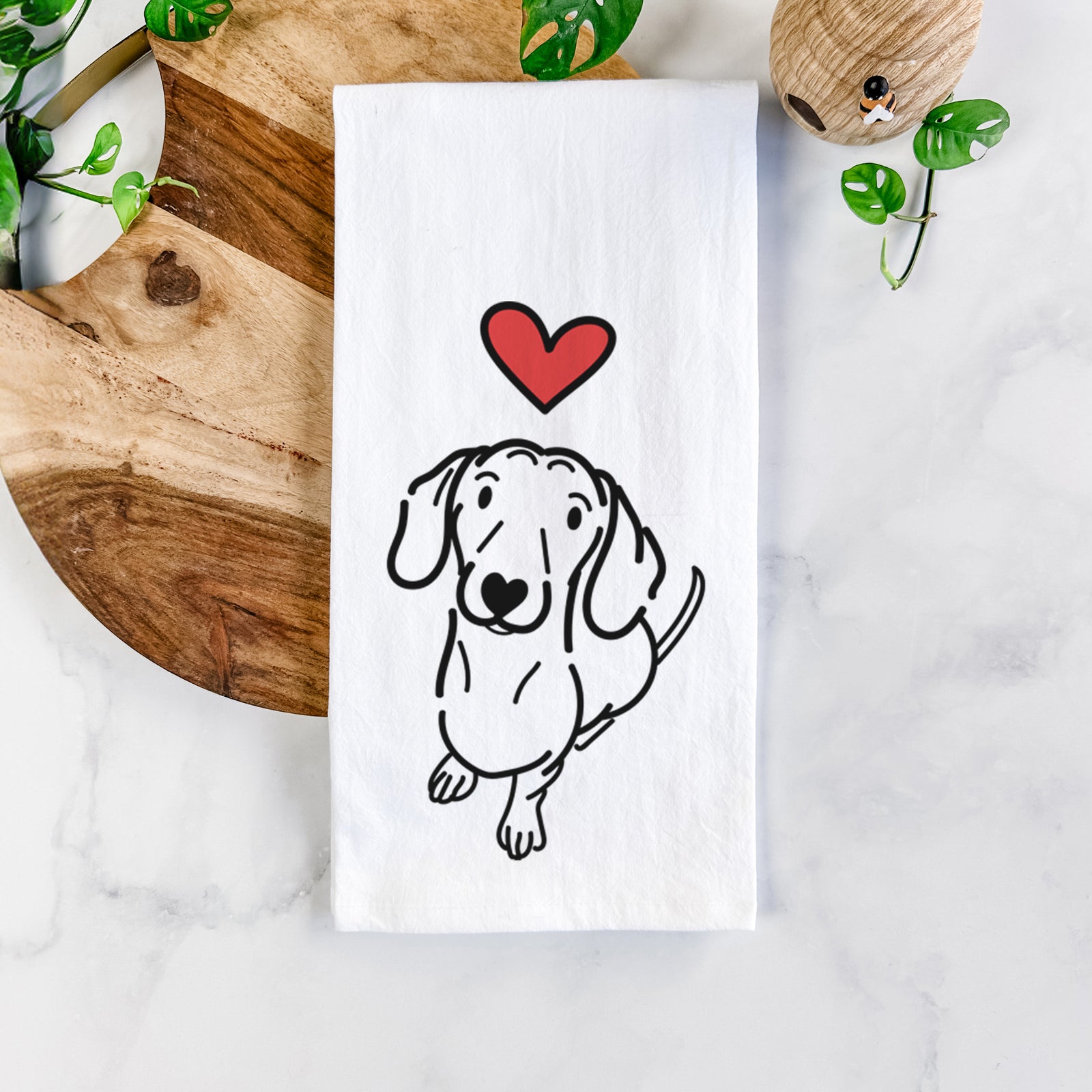 Minimalist line drawing of Moxie the Dachshund with a red heart on a tea towel