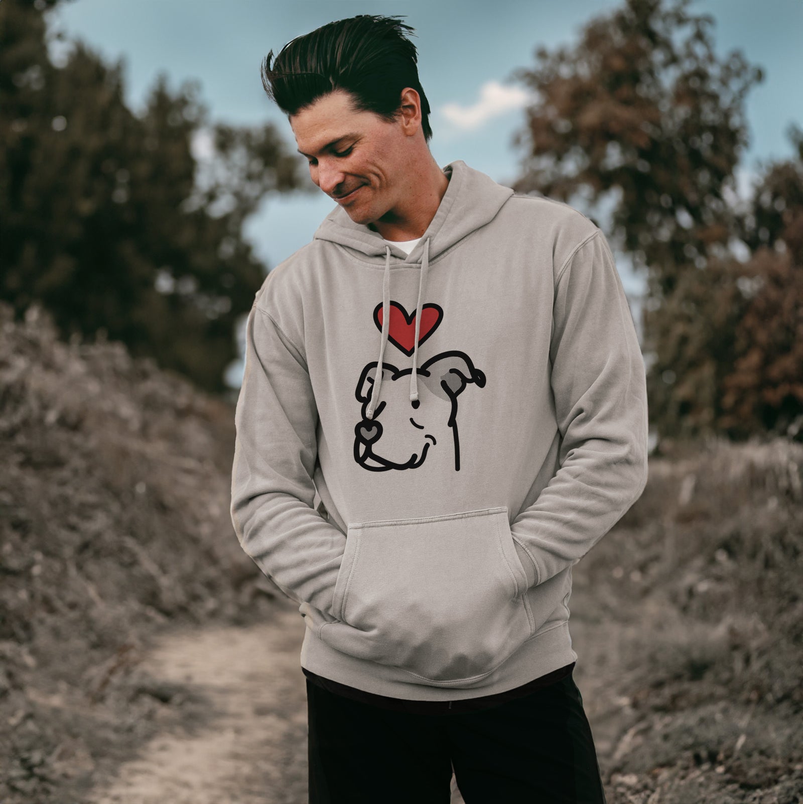 Minimalist line drawing of Mr. Sir the Pitbull Mix with a red heart on a Cement Unisex pigment dyed hoodie, worn by a man