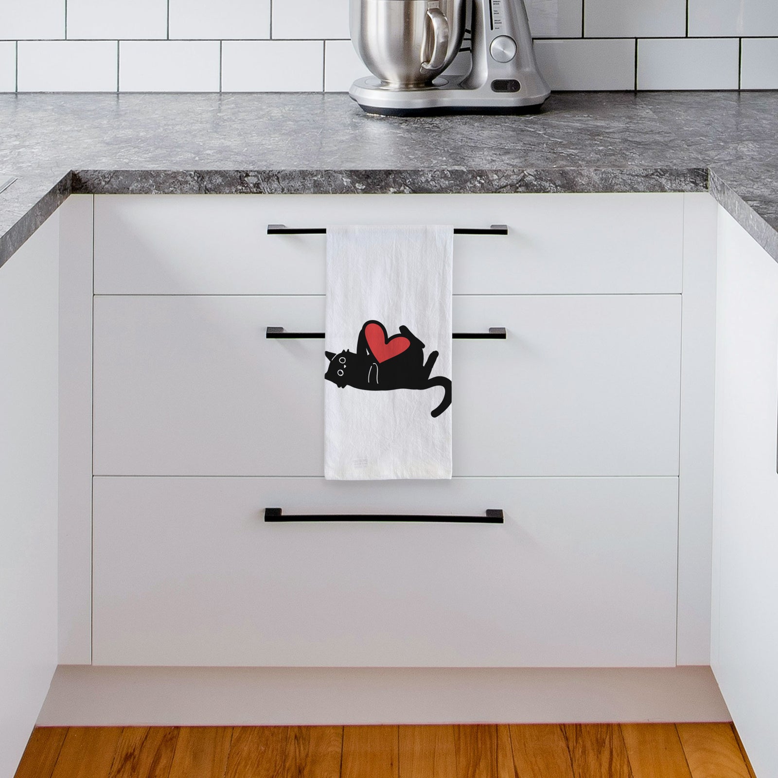 Minimalist line drawing of Smash the Black Cat with a red heart on a tea towel, hanging on an oven door in a kitchen